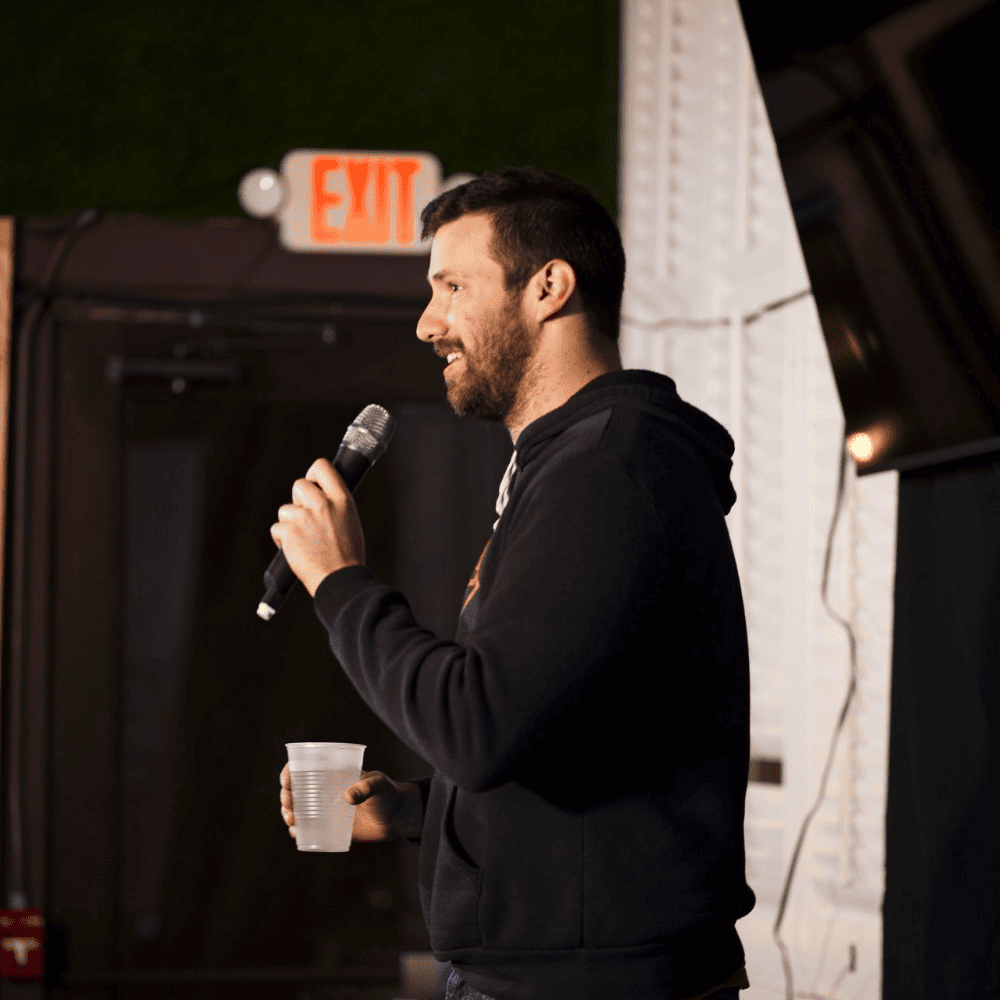 A profile view of a comedian on stage at a St Pete Standup show