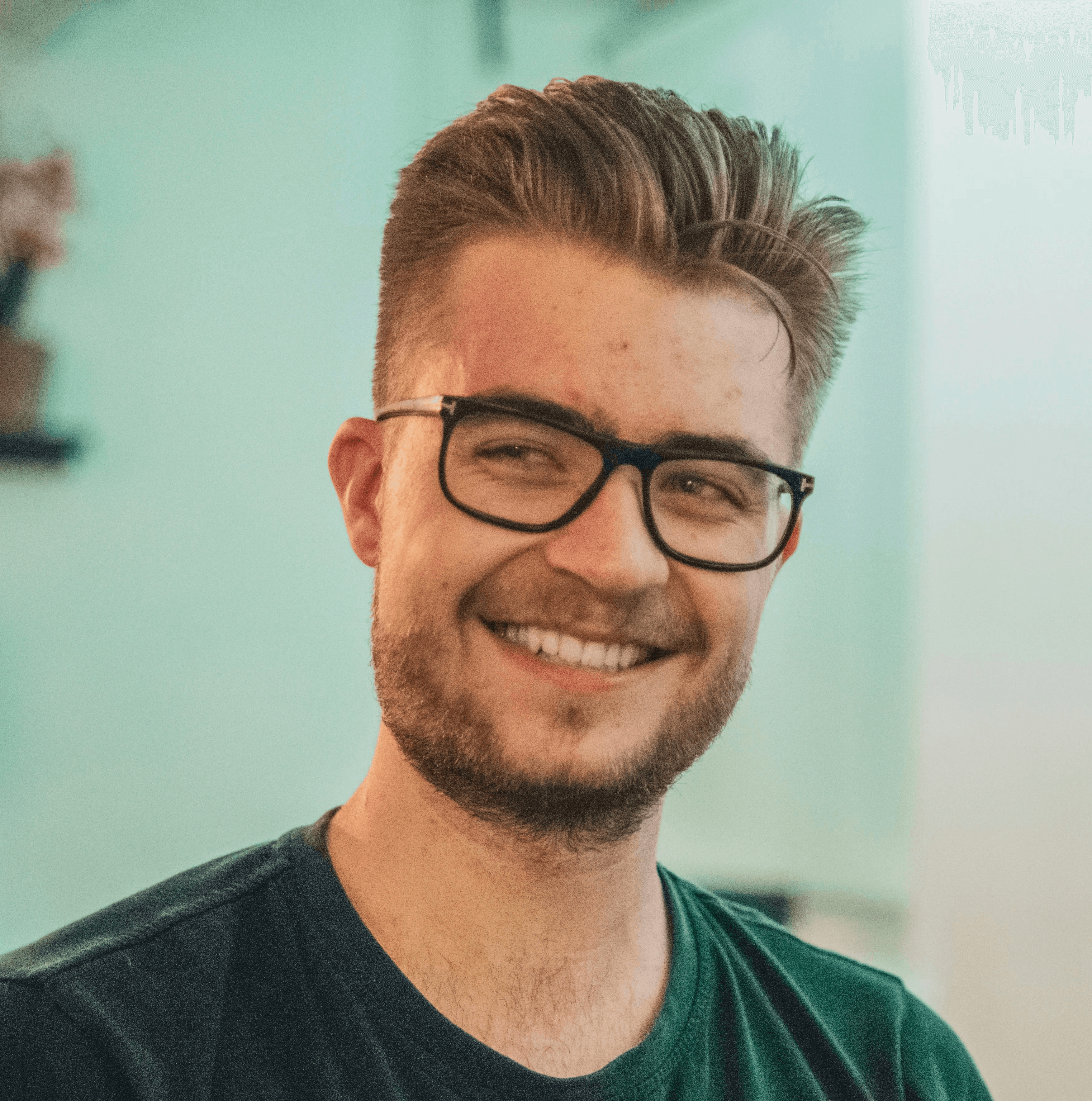 man wearing green crew-neck top and eyeglasses with black frames looking at side