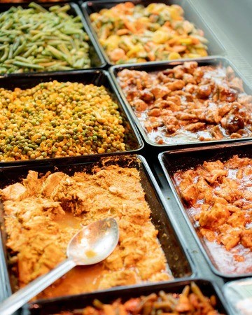 A beautifully arranged table with various dishes, including fruits, bread, and wine, set for a meal.