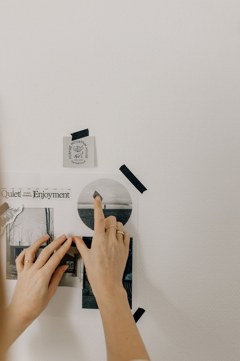 Zwei Hände hängen Bilder für Websiten Inspiration zu einem Moodboard an eine Wand