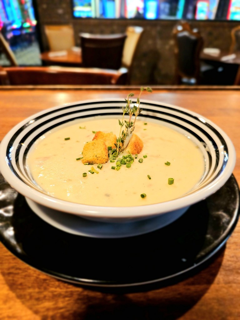 A hearty bowl of soup served on a rustic wooden table at Dueling Pistols Restaurant.