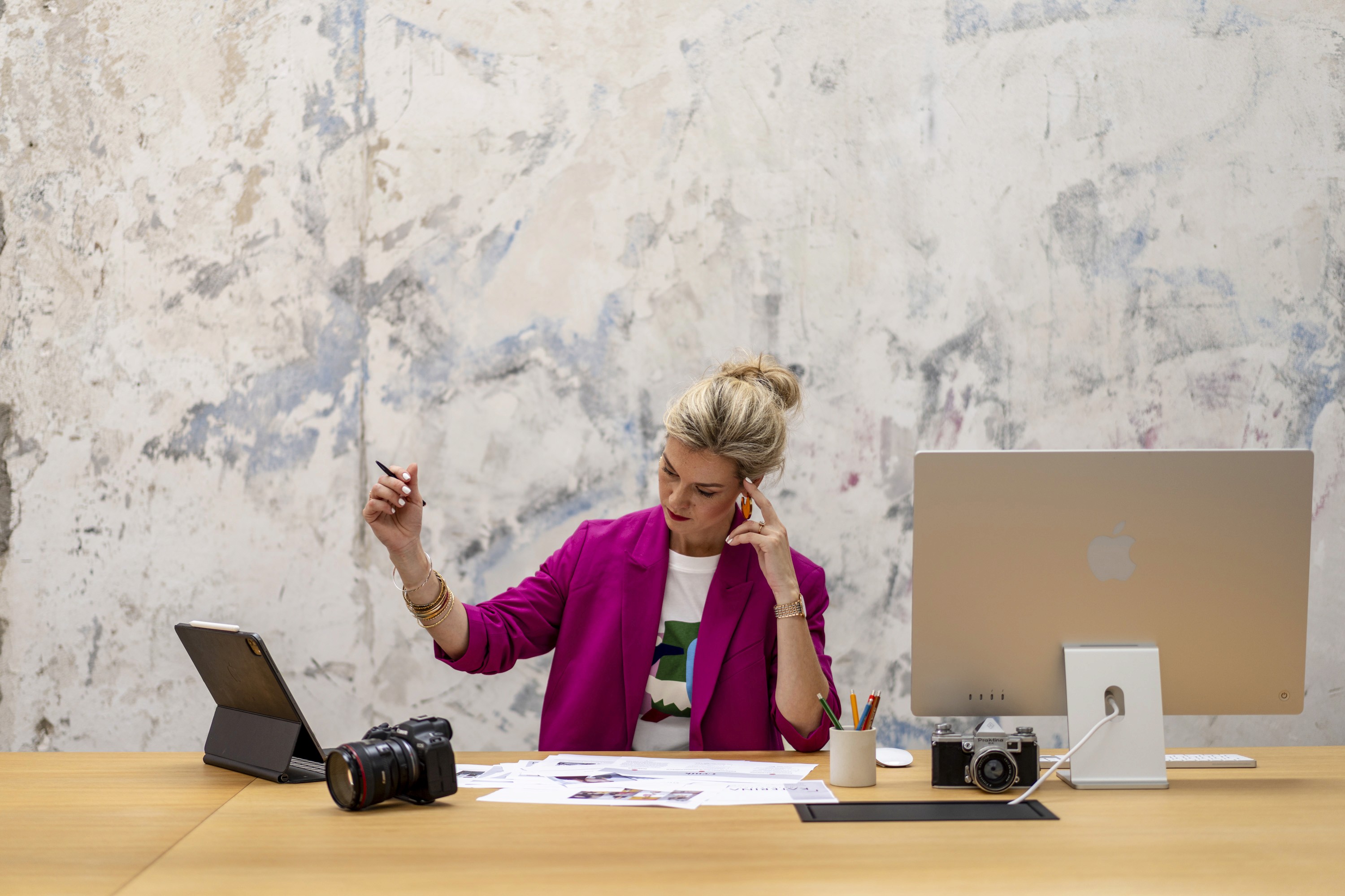 Brand photoshoot showing a creative professional working at a desk in a studio environment.