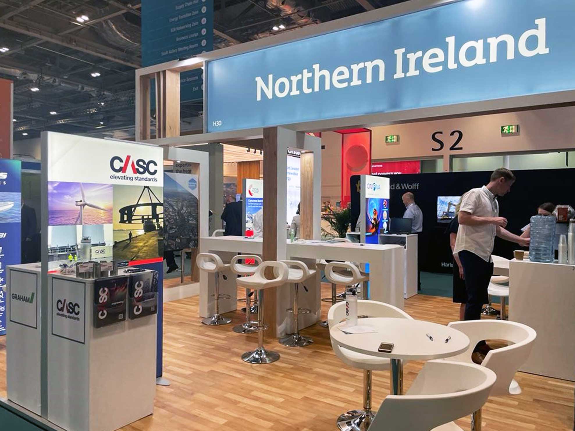 Northern Ireland exhibition stand at a trade show with seating and display panels.