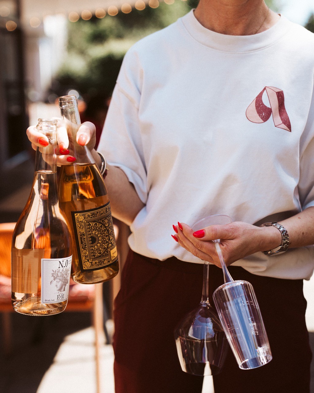 woman holding wine bottles at a restaurant ready to serve them to guests