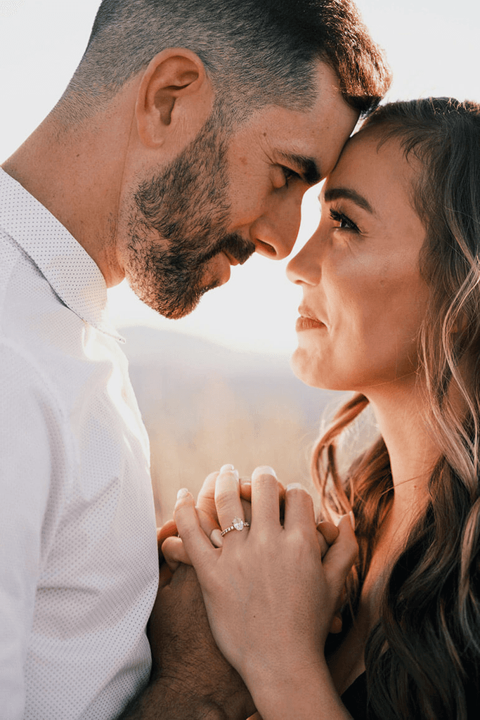 A couple stands closely in an intimate embrace.