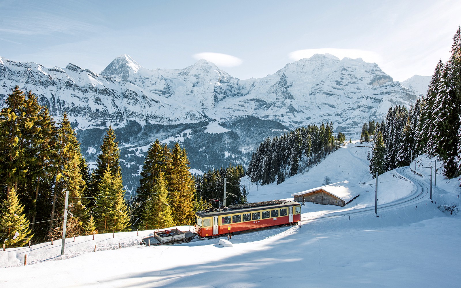 Lauterbrunnen-Mürren cableway train in snowy Swiss Alps landscape.