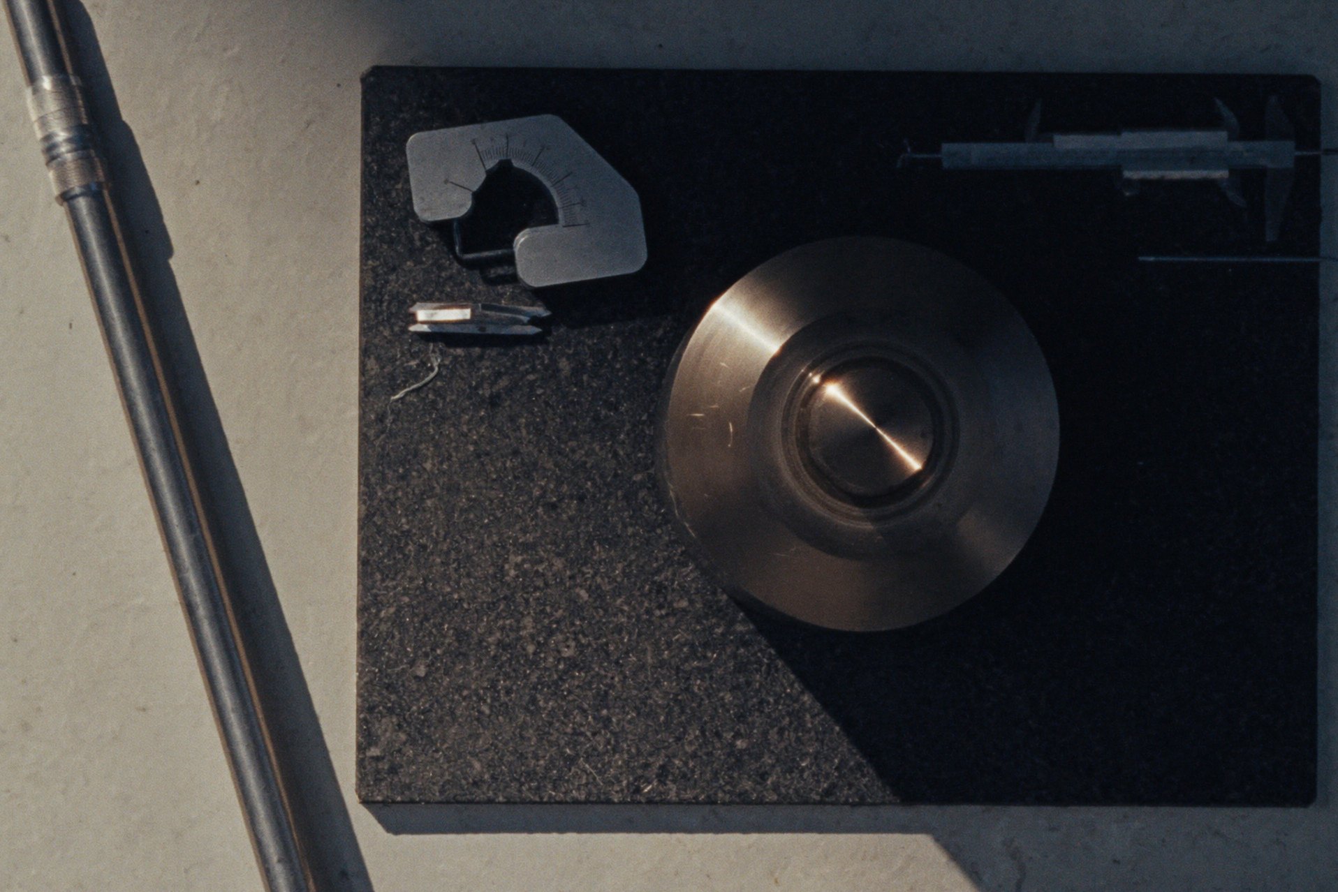 A micrometer, calipers and gauge blocks on a granite surface plate