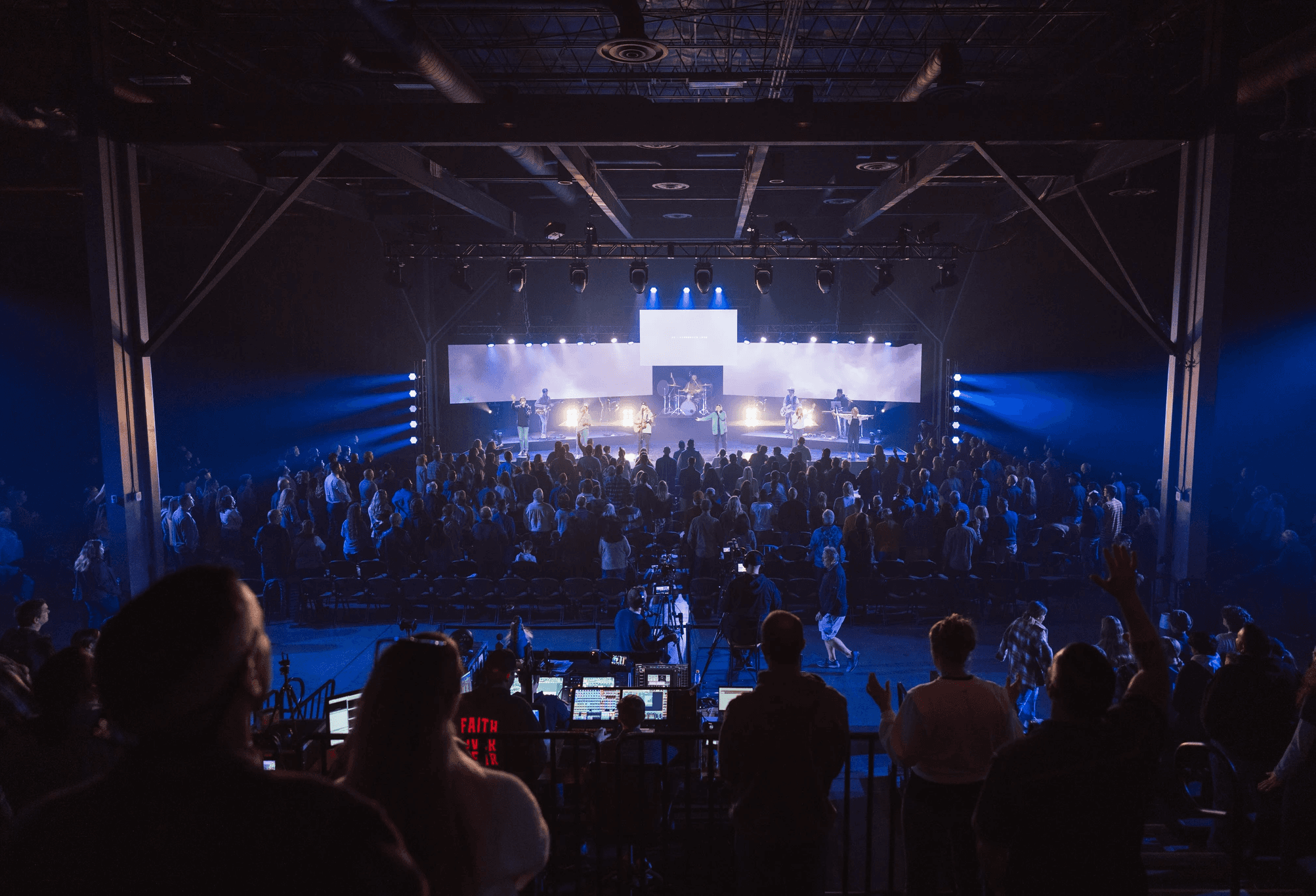 two people in a workspace working on their laptops