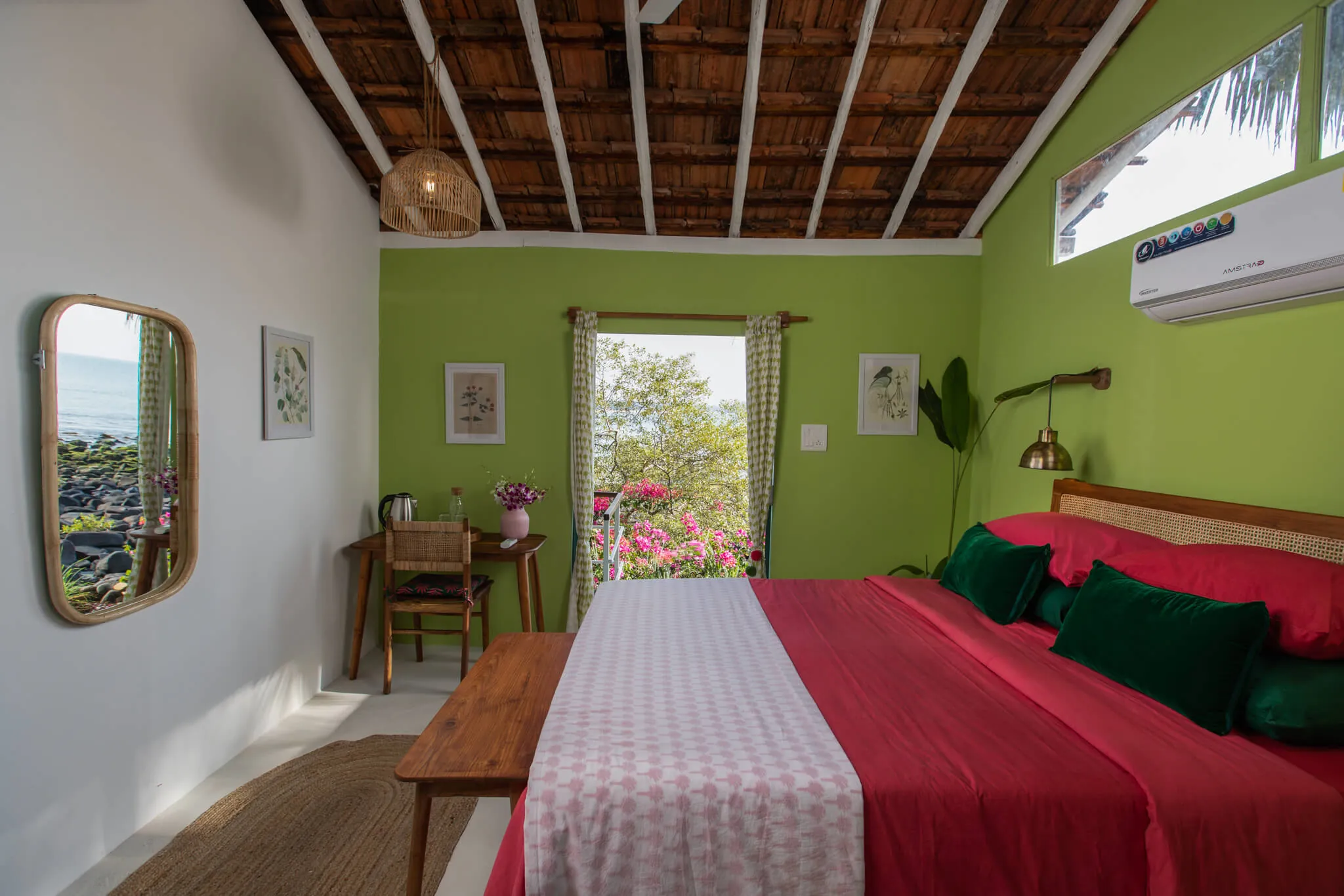 Green-walled bedroom opening to a sea balcony at Casa Jaali