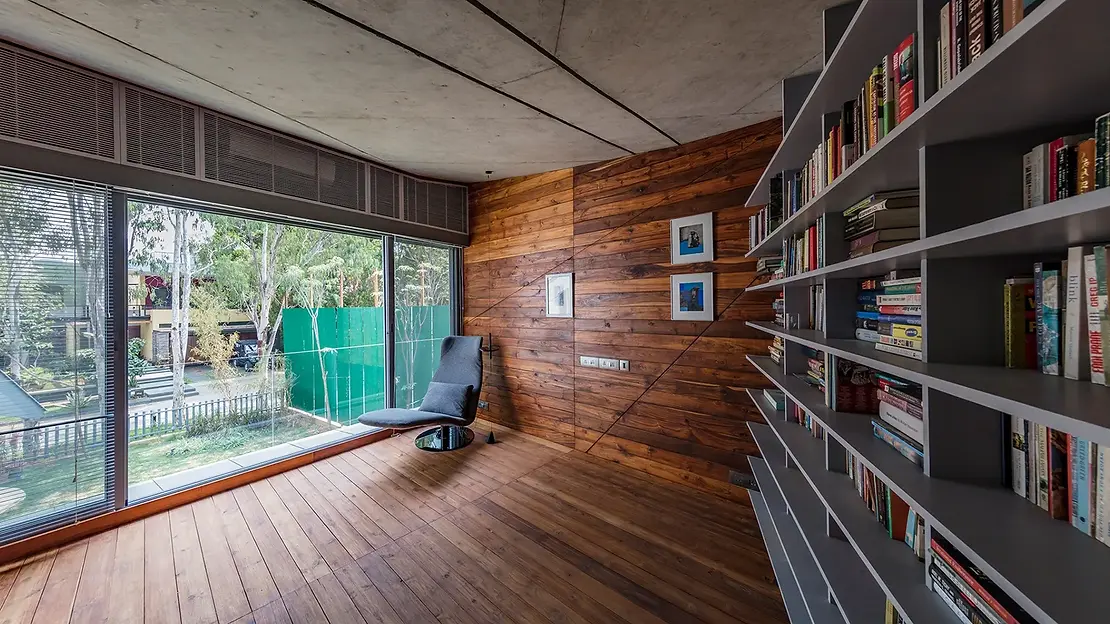 Modern minimalist reading room with wooden floor and wall with large glass window
