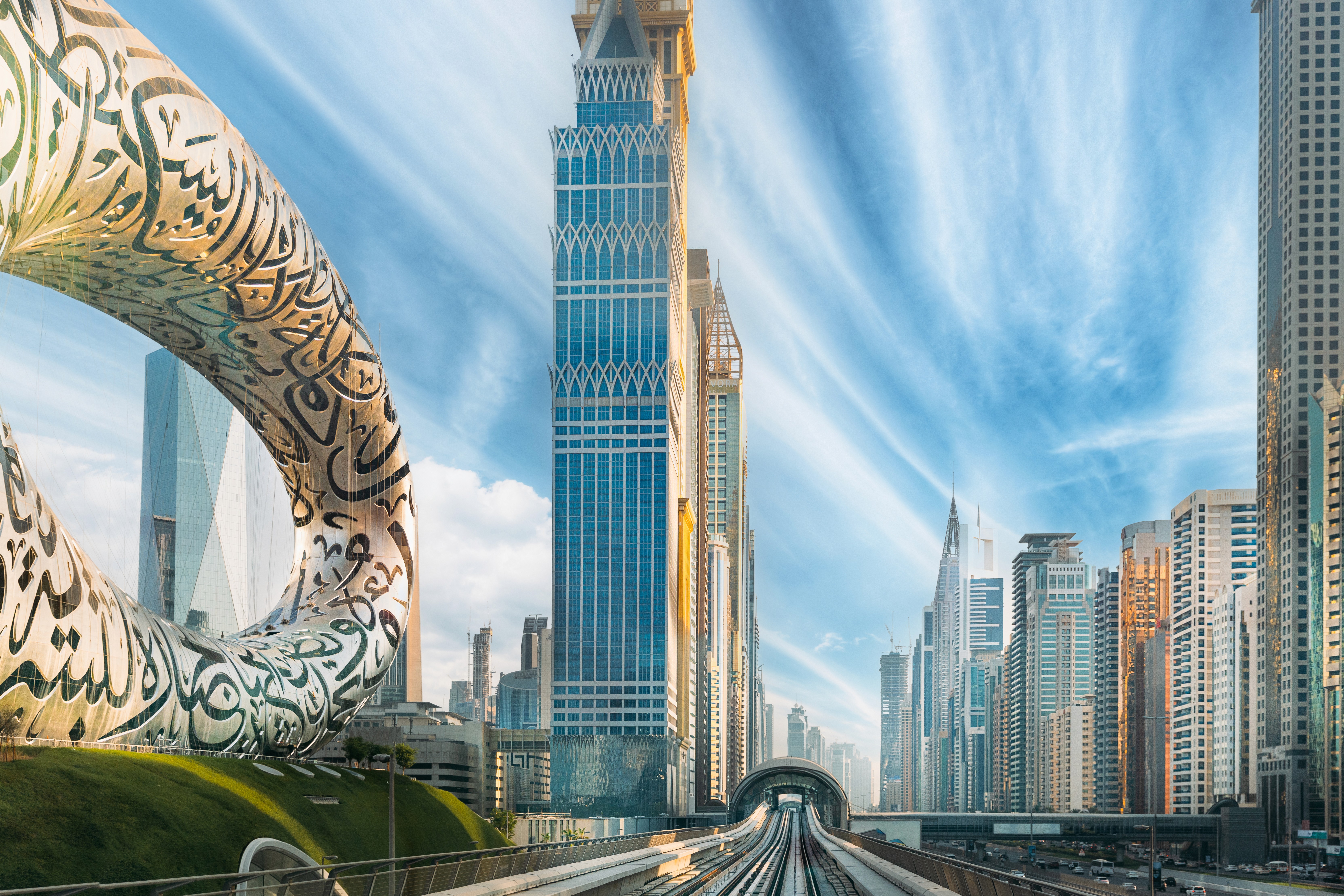 Man with a beard in a dark button-up shirt, smiling while writing in a notebook.