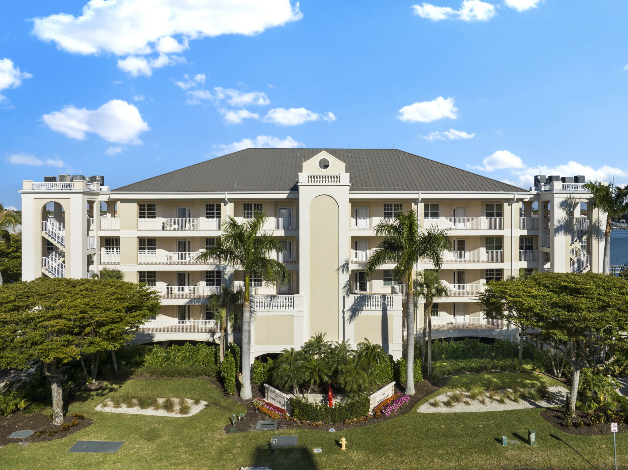 a condo building surrounded by palm trees