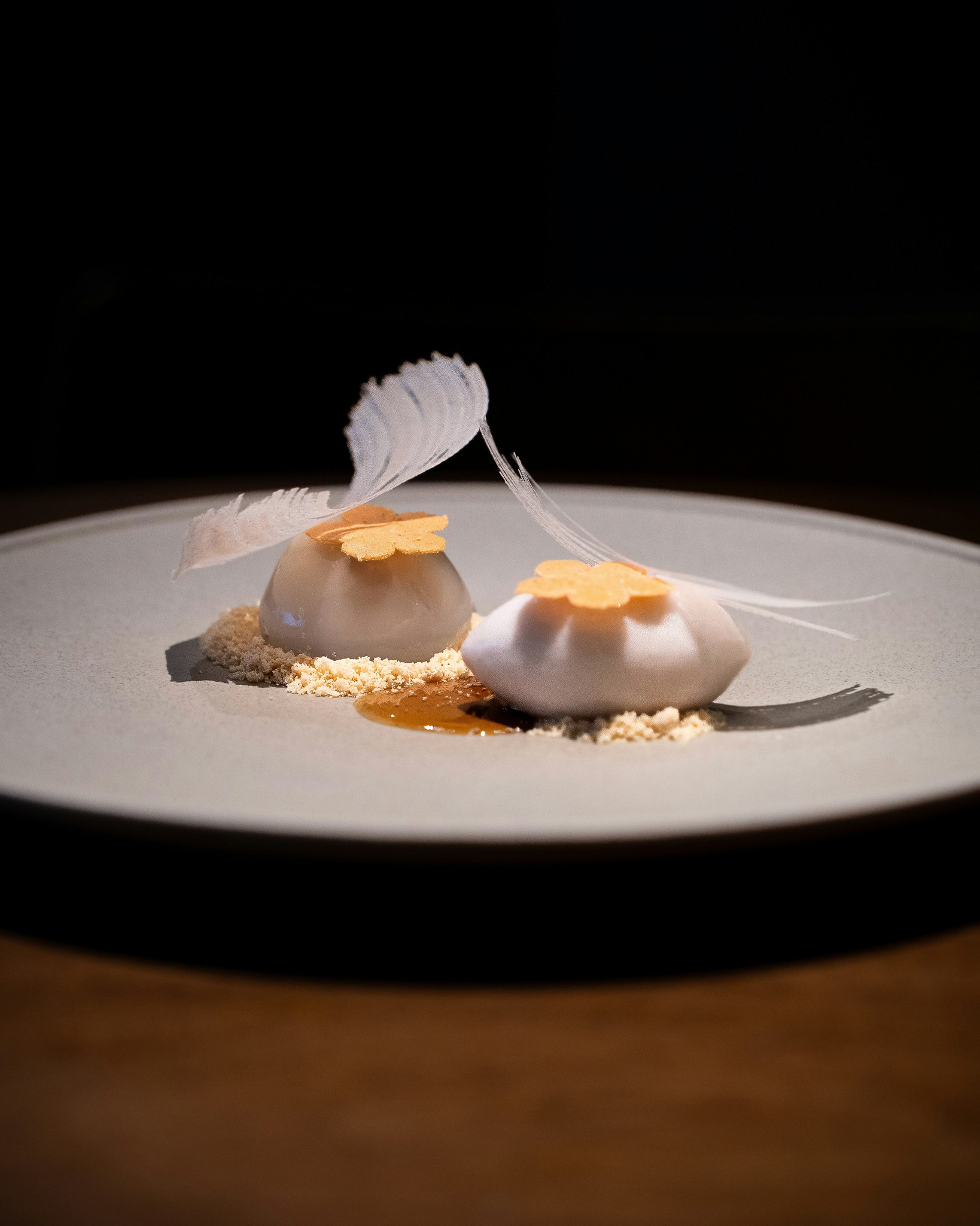 Stacked square glass jars filled with golden serum and bubbles, silver lids—luxury skincare packaging on a light background.