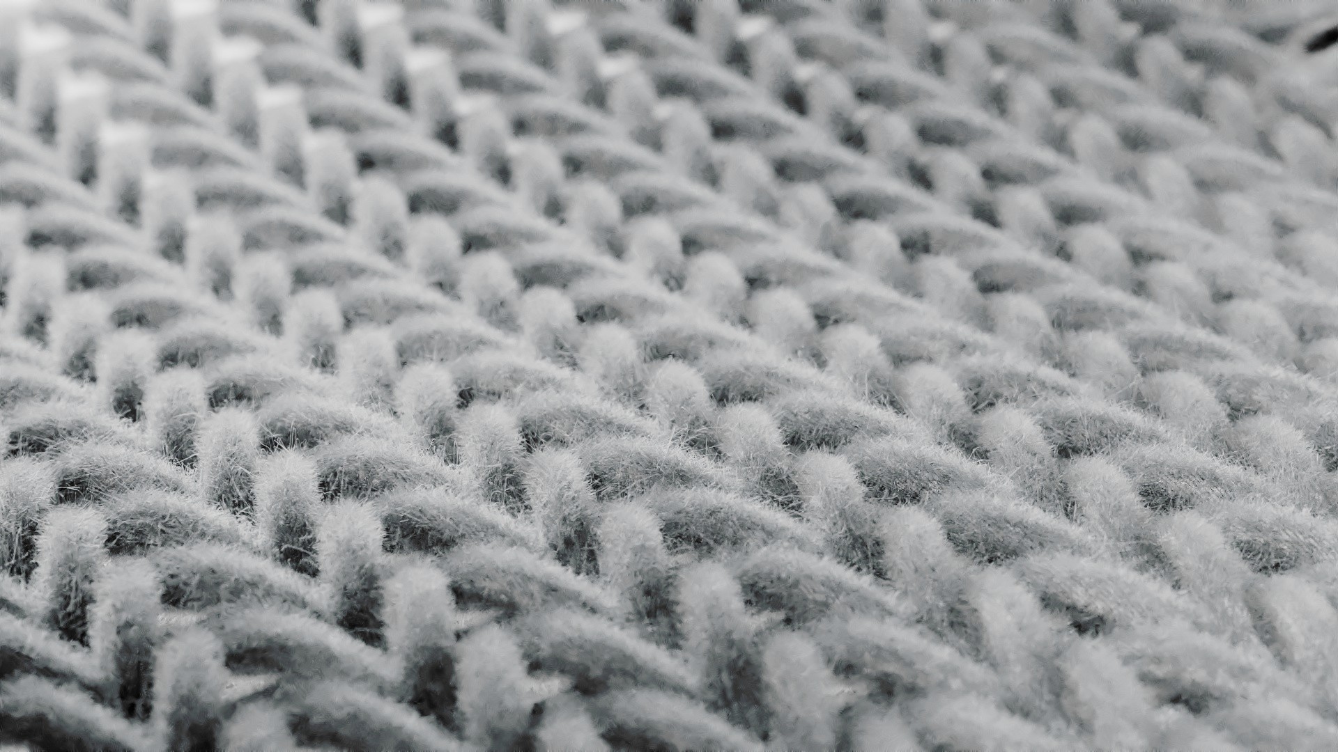 Weitwinkelansicht der gerenderten Strickstruktur mit gleichmäßigem Muster und neutralem Hintergrund