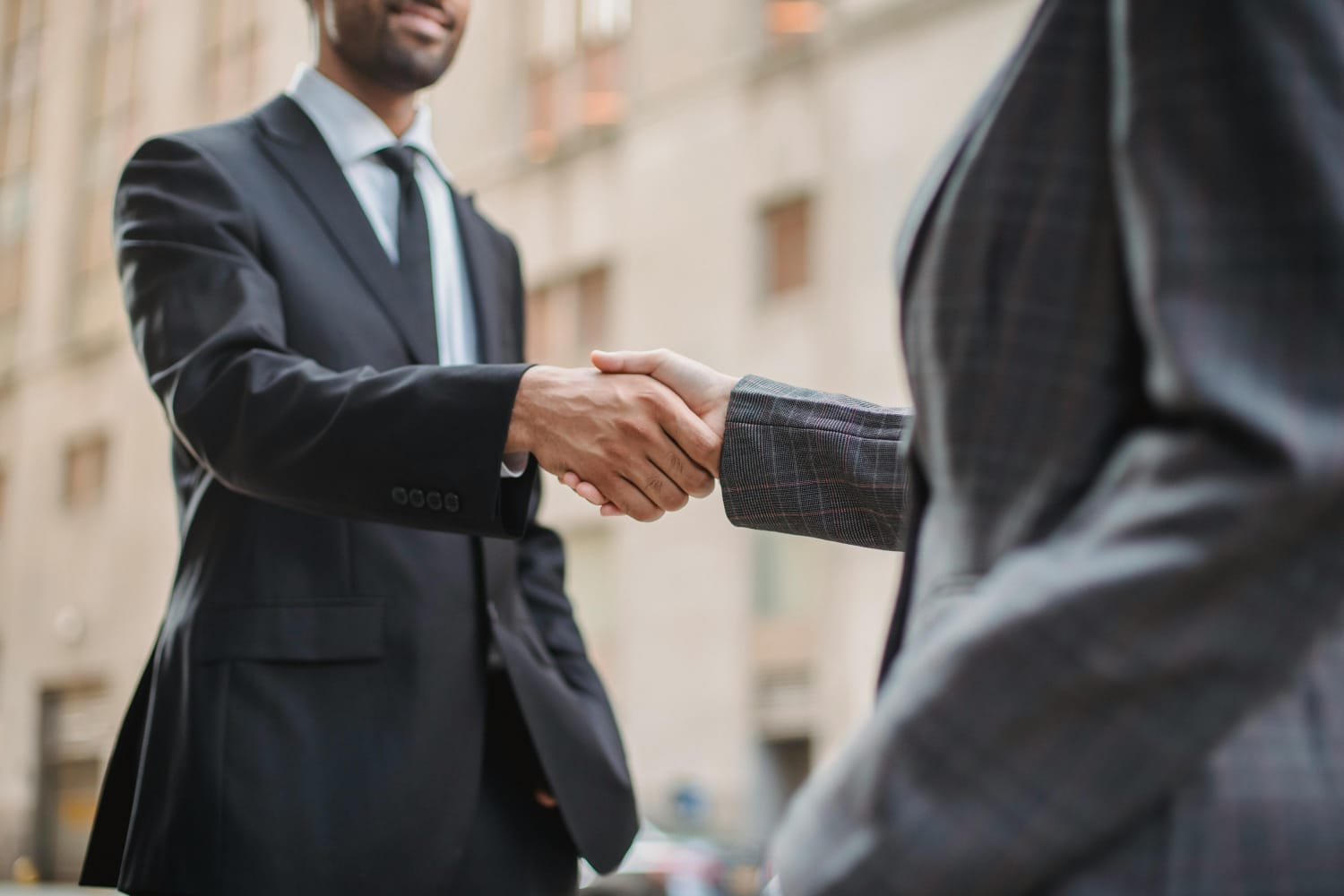 Two professionals shaking hands to close a business deal.