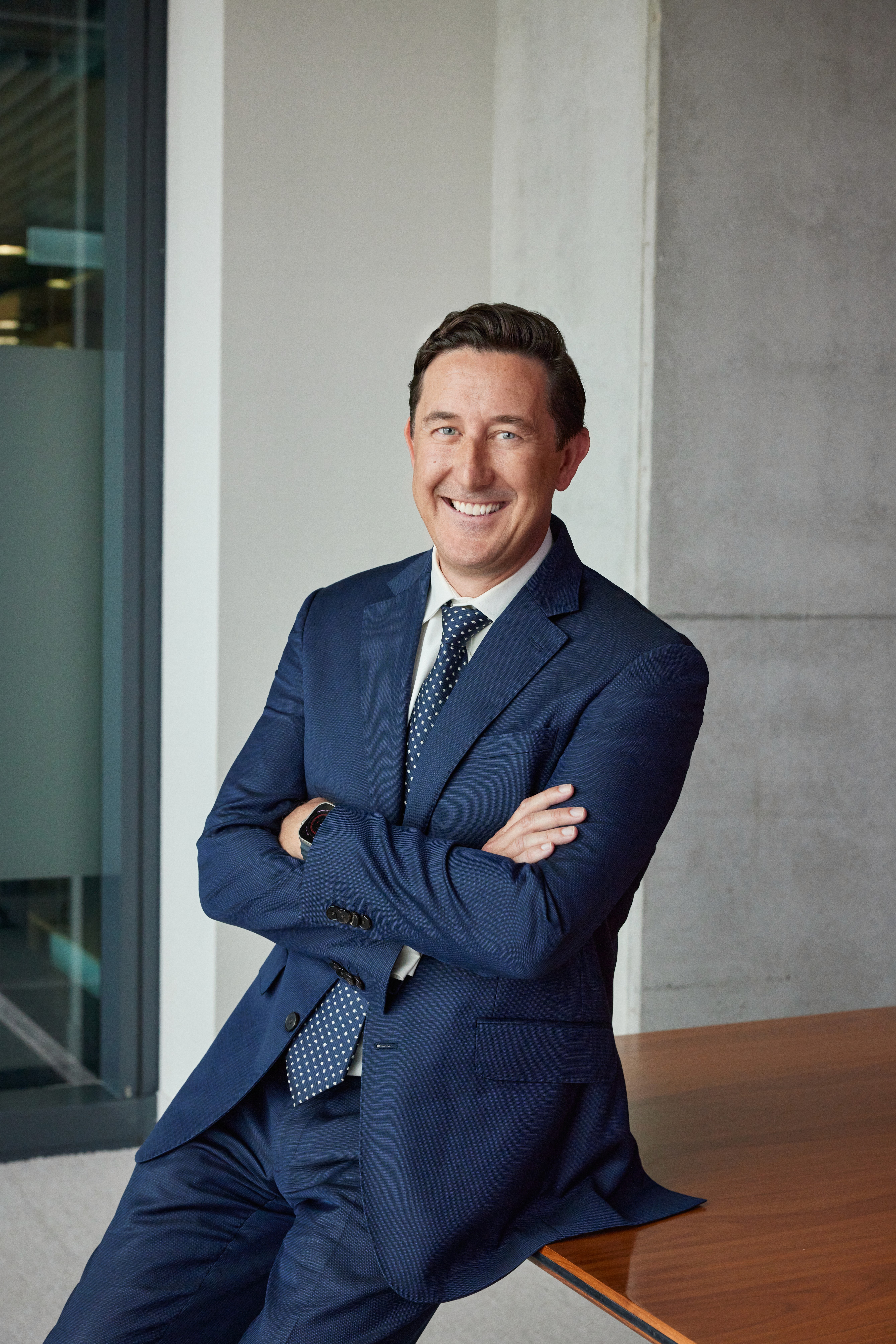 Editorial corporate portrait in Sydney by photographer Cybele Malinowski, featuring a male executive in a navy suit with crossed arms. swiss re CEO