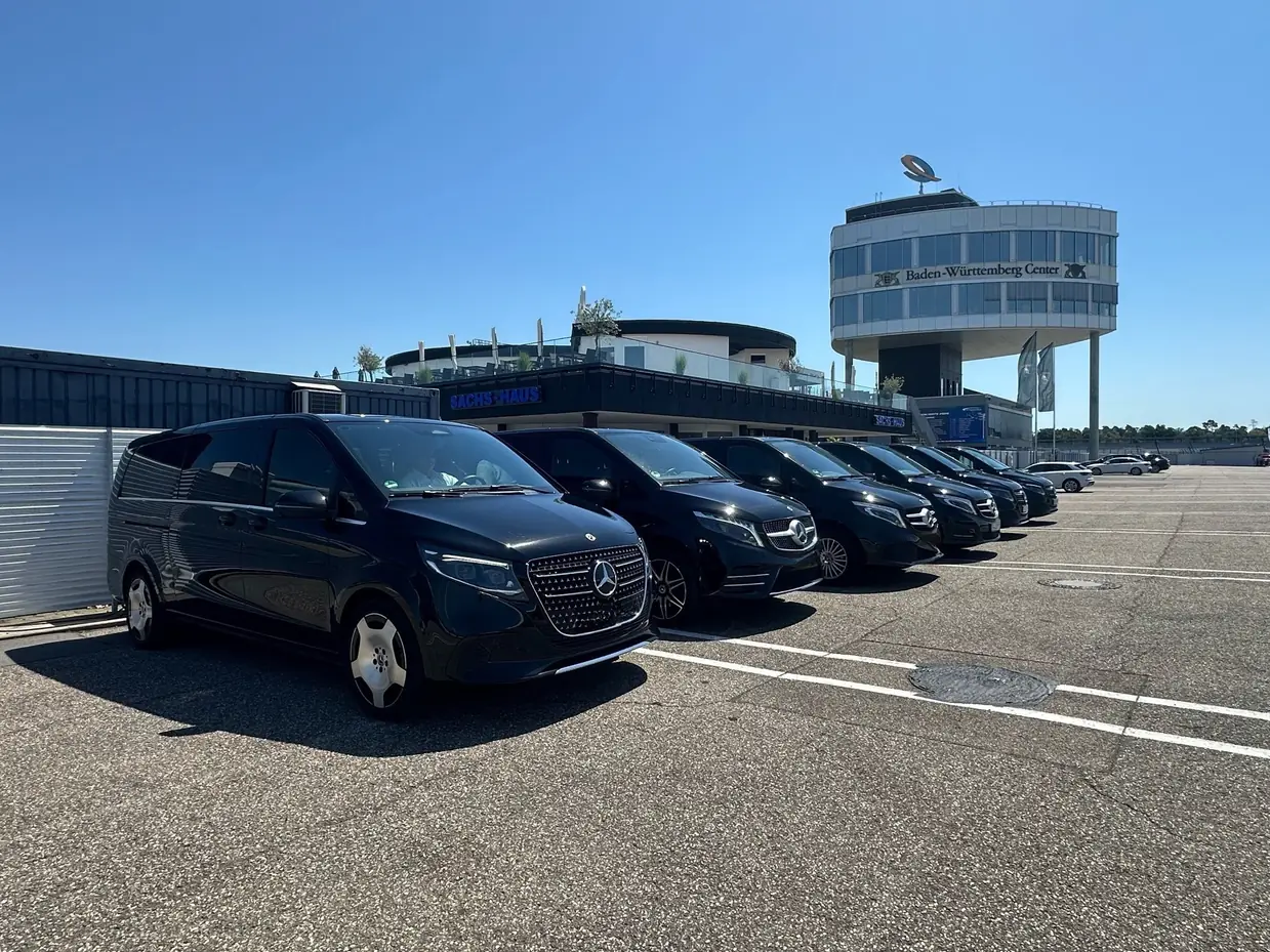 Aufgereihte Mercedes V-Klasse Shuttlefahrzeuge vor einem Veranstaltungsgelände