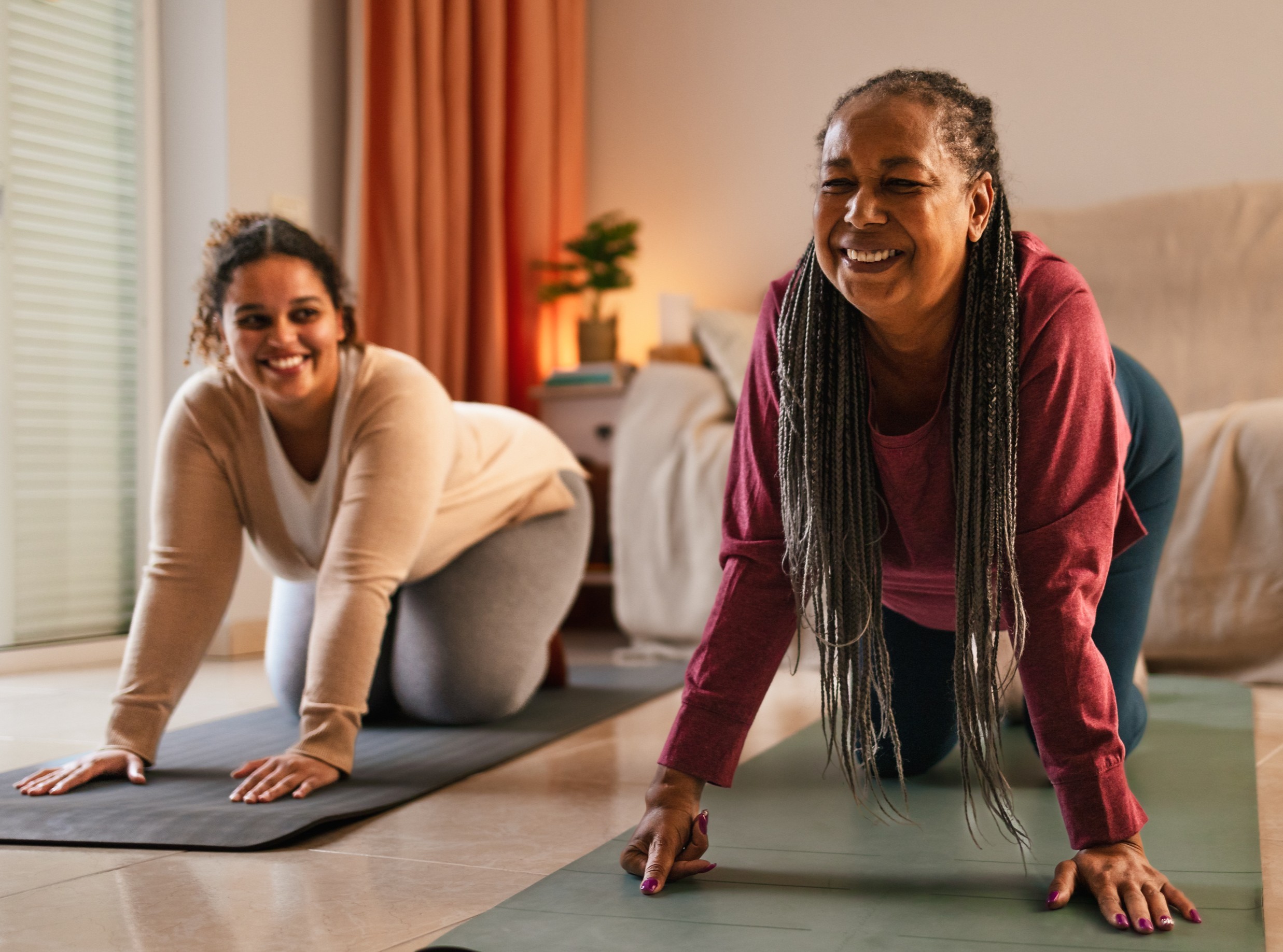 mom and daughter having a good time doing fun weight loss workouts at home on workout mats