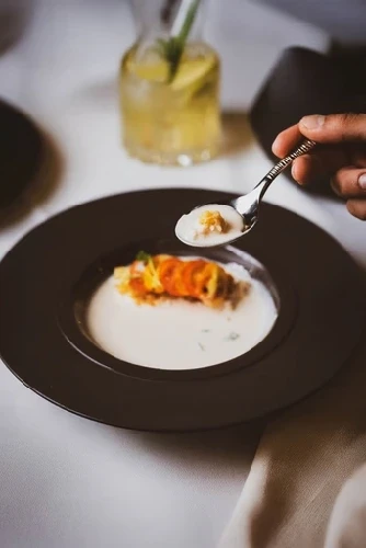 Gourmet dish with garnish artfully plated on a dark ceramic plate