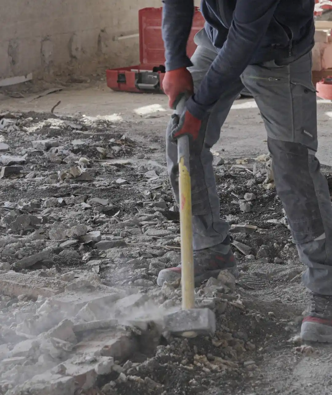 Arbeiter mit Hammer bei Abbrucharbeiten auf einer Baustelle