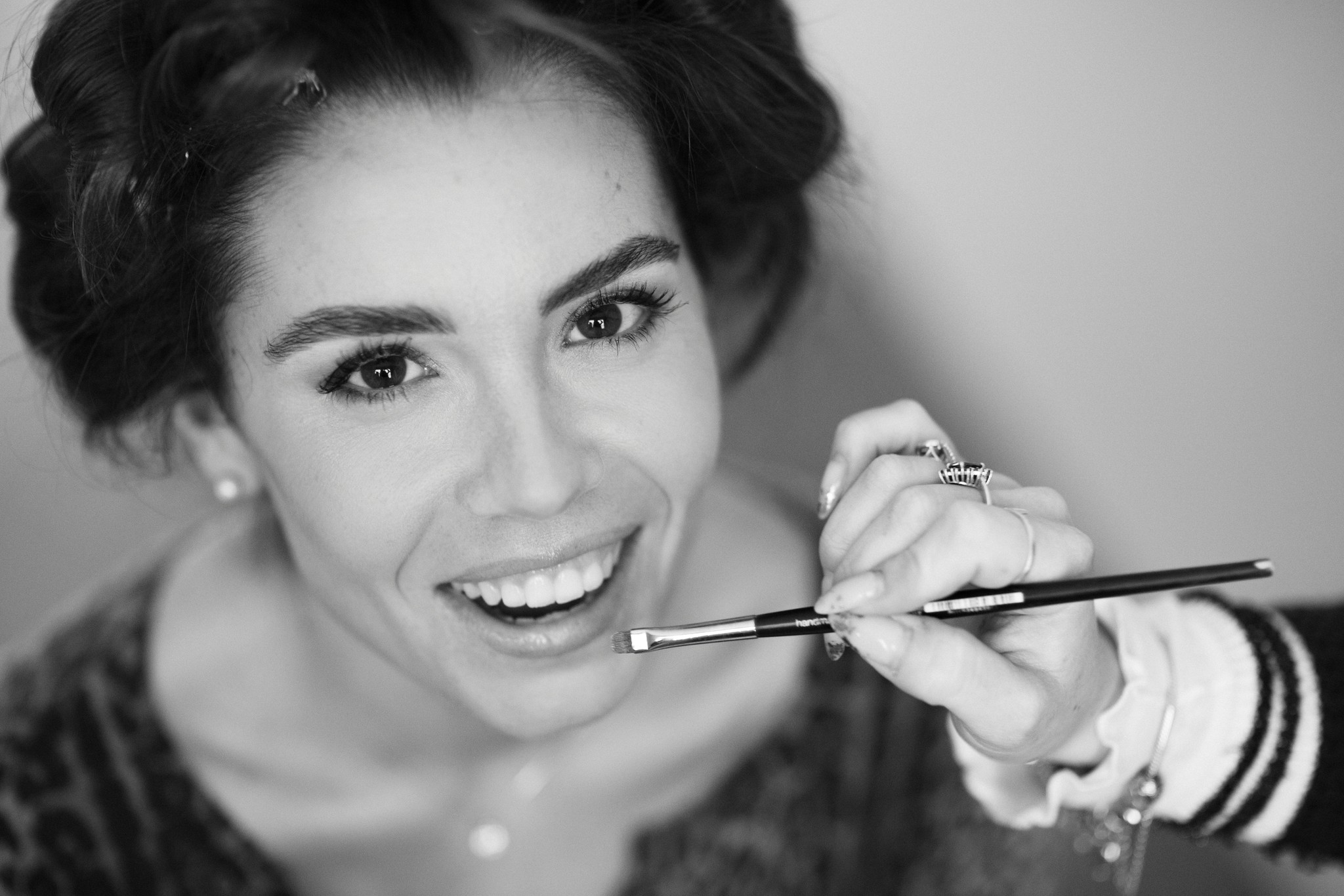 Sposa sorridente durante i preparativi del trucco nuzia al Circolo di Lettura di Parma, anello d'oro visibile