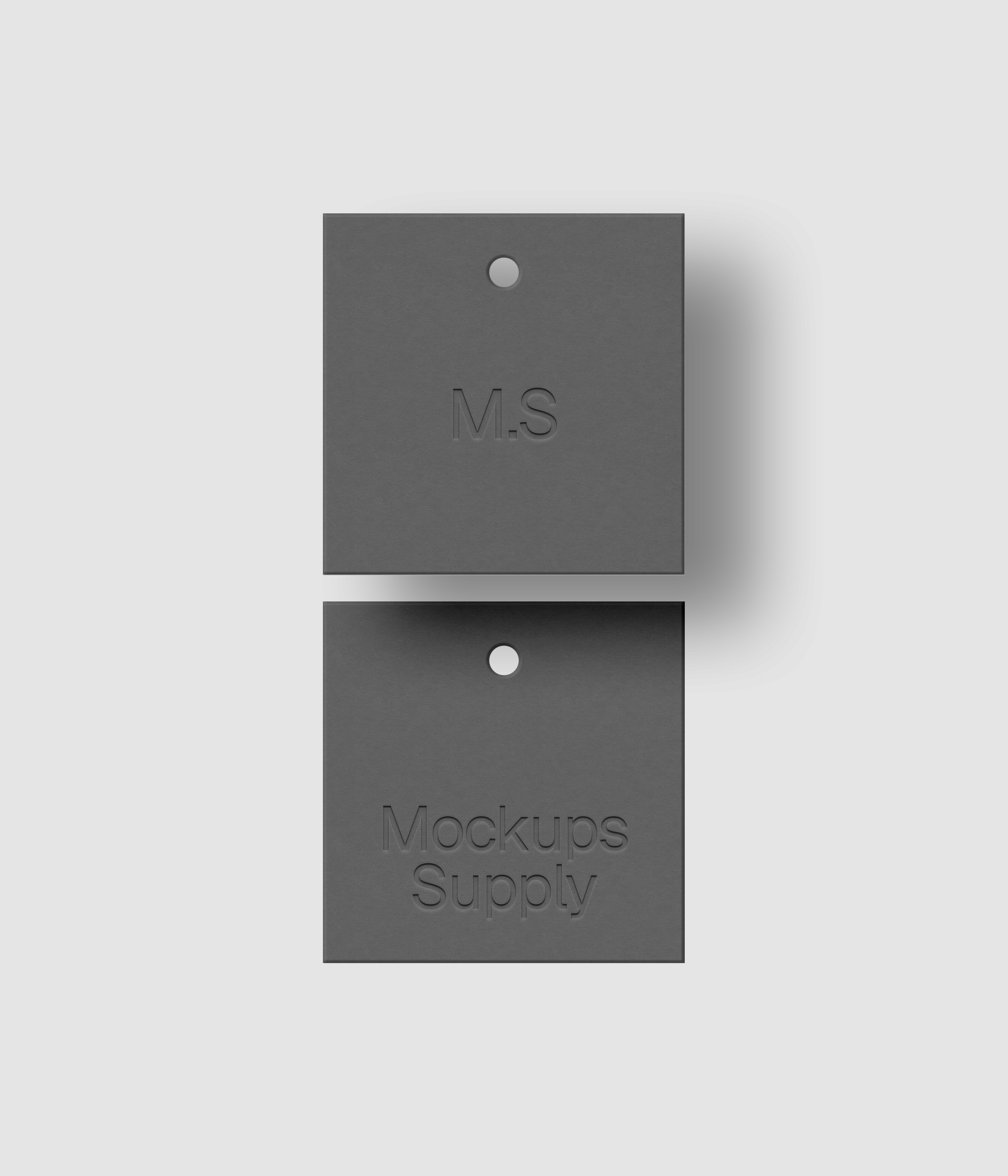 Two square gray clothing label mockup on white background with natural shadow depth and debossed text effect for Photoshop download psd