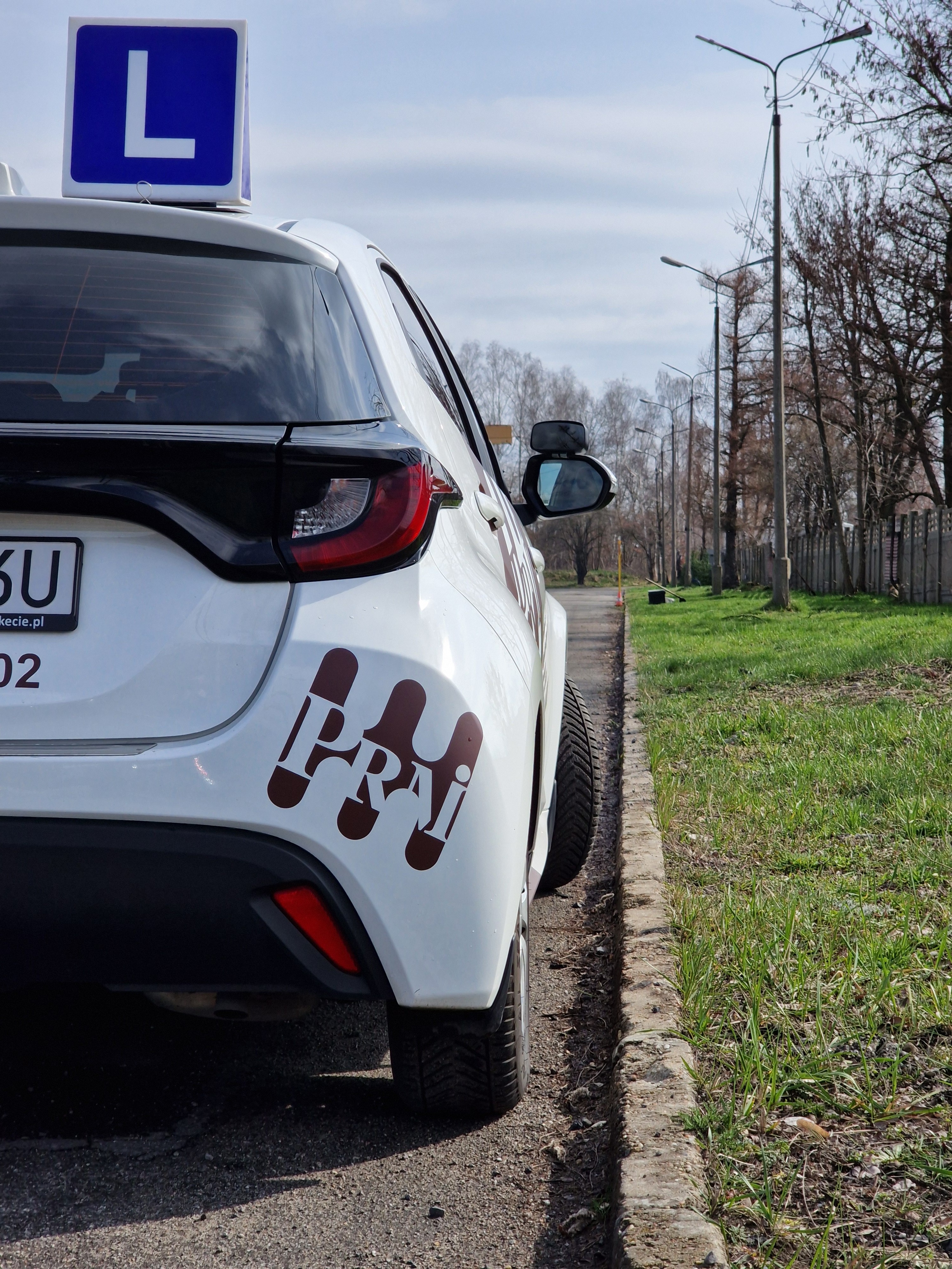 Widok z wnętrza samochodu podczas jazdy miejskiej, kierowca obserwuje drogę.