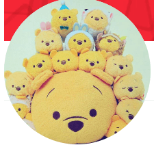 The image shows a group of small yellow plush bears surrounding a large bear's head, with some wearing cute accessories.