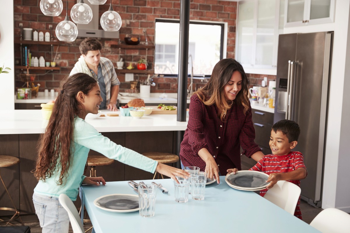 Family setting the dinner table