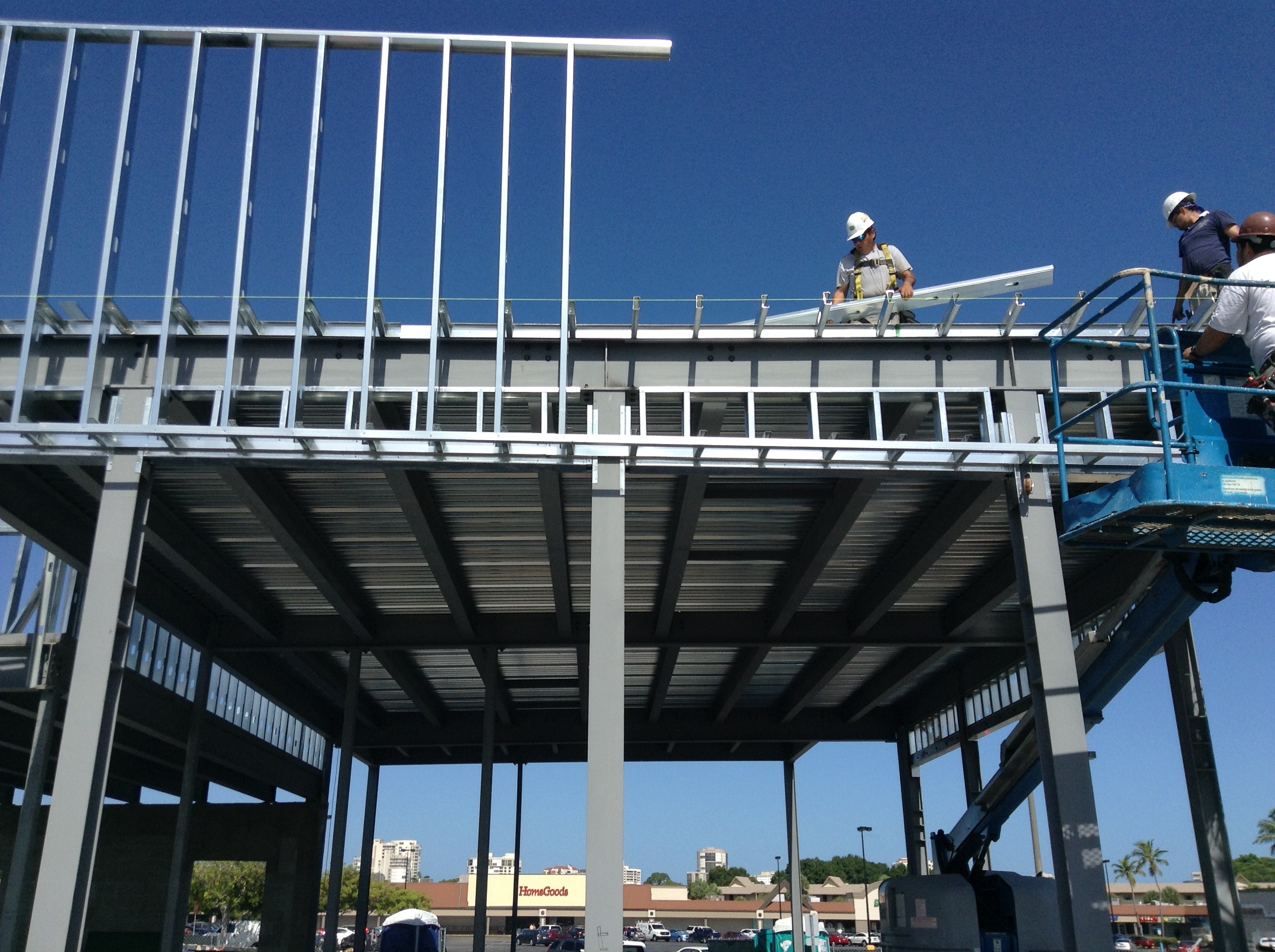 a man standing on top of a metal frame of a building under construction