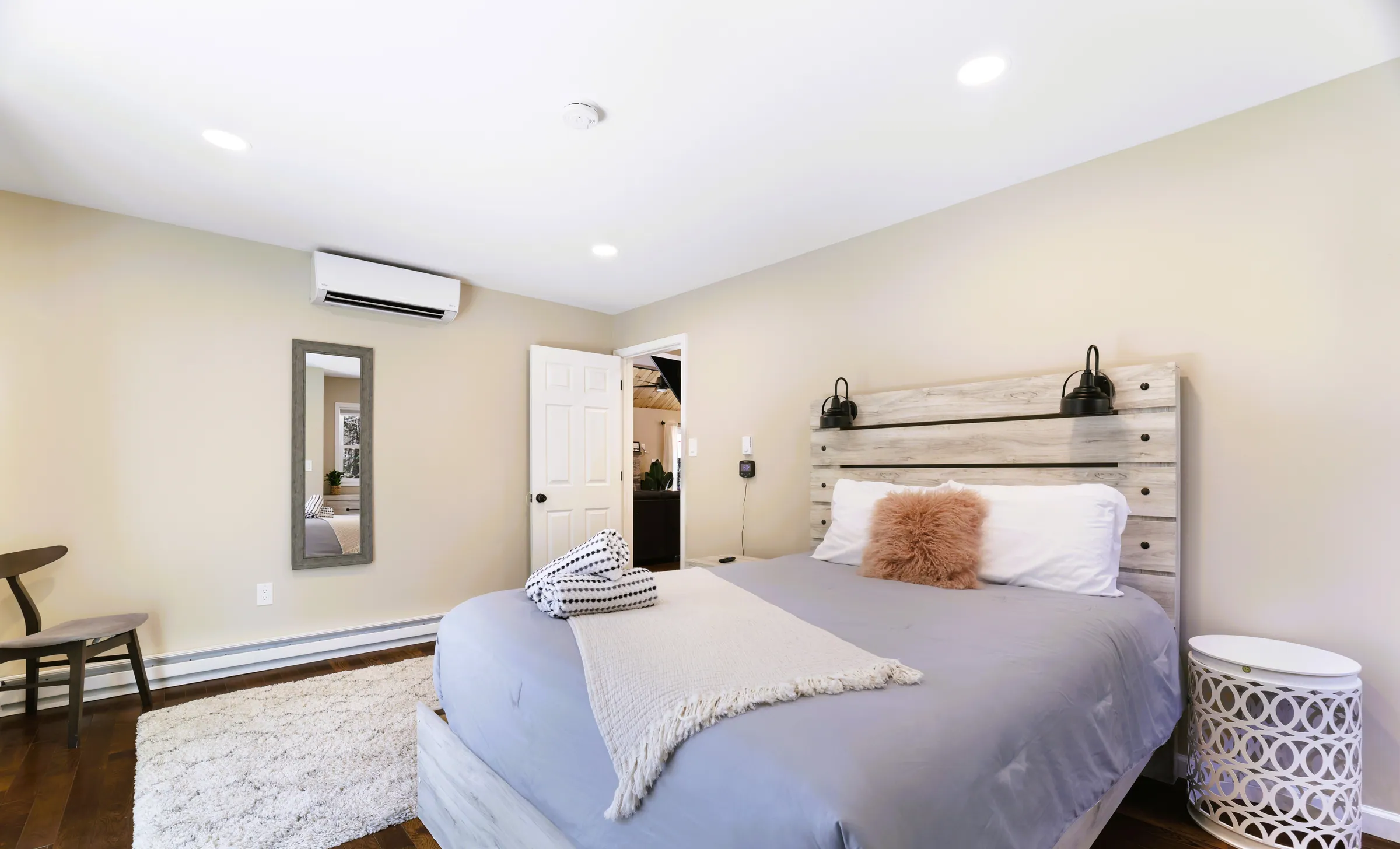 Main floor queen bedroom with reading sconces and mini-split AC at Divine on Lupine