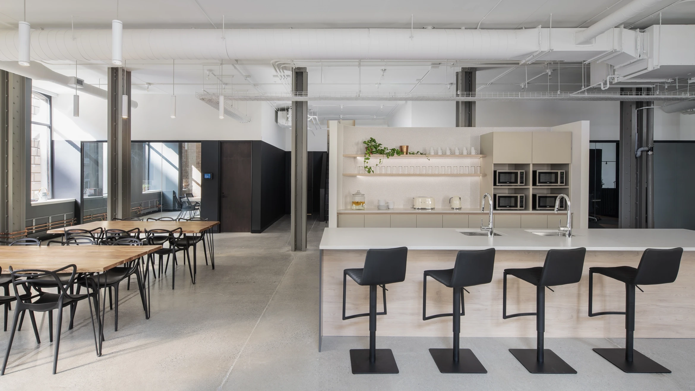 Kitchen and communal area at Dialogue, designed with a neutral palette, industrial accents, and natural wood tones for a welcoming atmosphere.