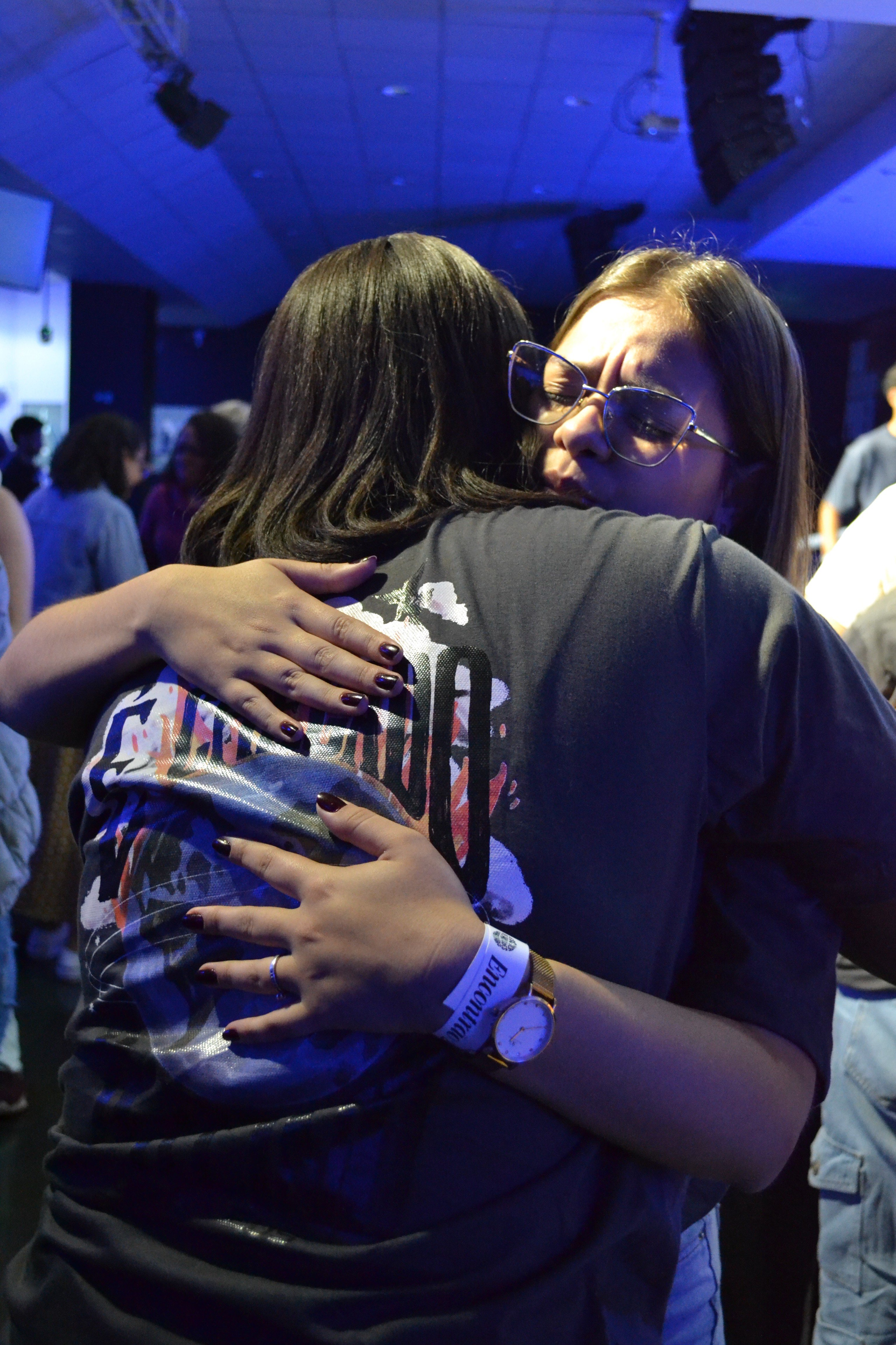Full moon rising over a dark, silhouetted mountain ridge.