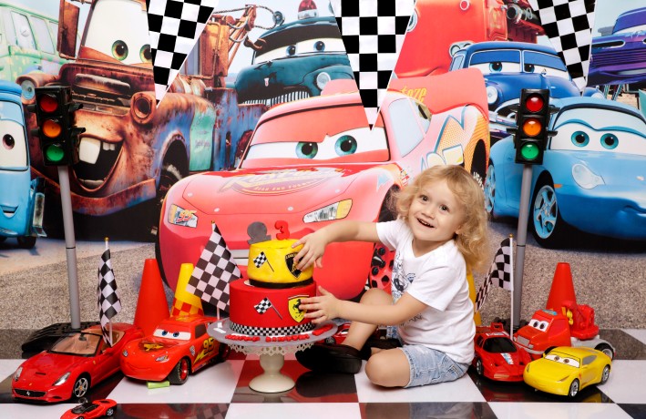 A child celebrating a 3rd birthday with a Cars theme