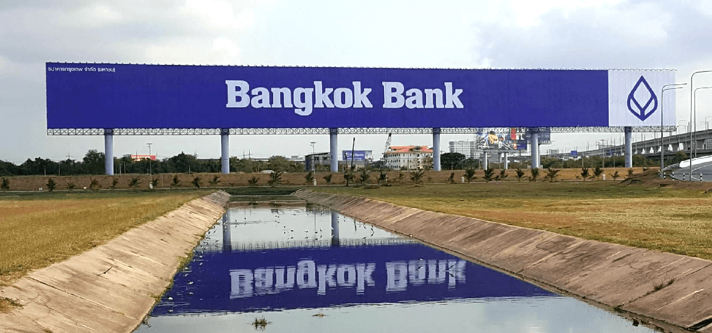 บิลบอร์ด Bangkok Bank บนป้ายยาว 201 เมตร สนามบินสุวรรณภูมิ เห็นทั้งแนวพาดต่อเนื่องบนเสาหลายต้น มีคลองสะท้อนภาพป้ายอยู่ด้านหน้า