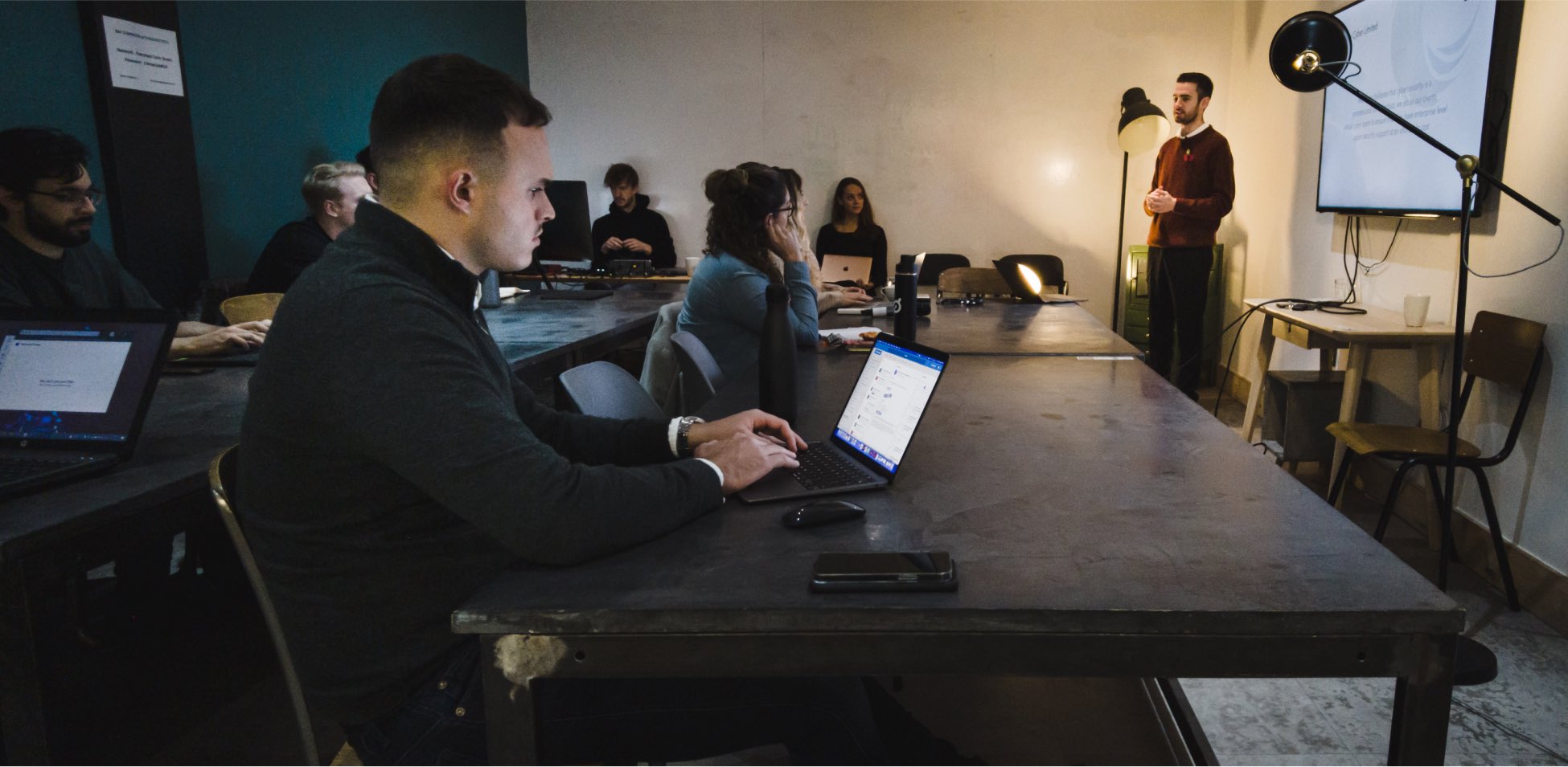 People gathered around a table with laptops and headphones.