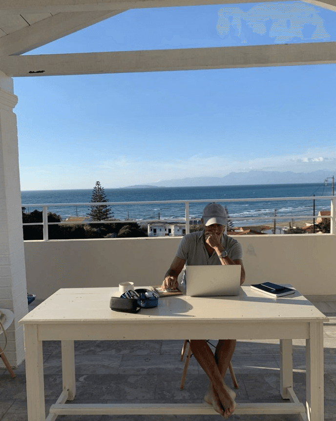 Helmut van Rinsum am Latop mit Meerausblick