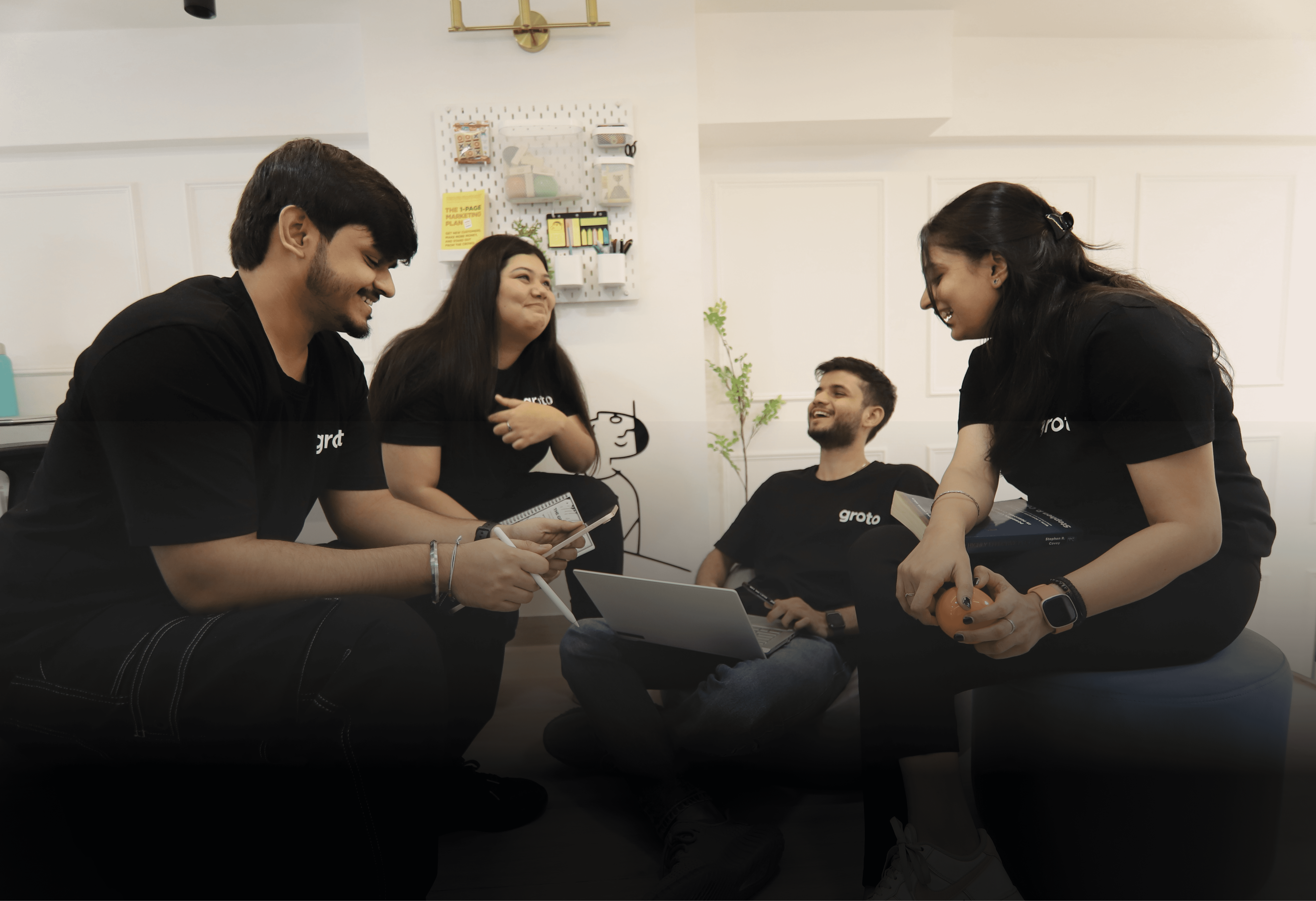 Three people sitting on a couch in a room looking at mobile devices