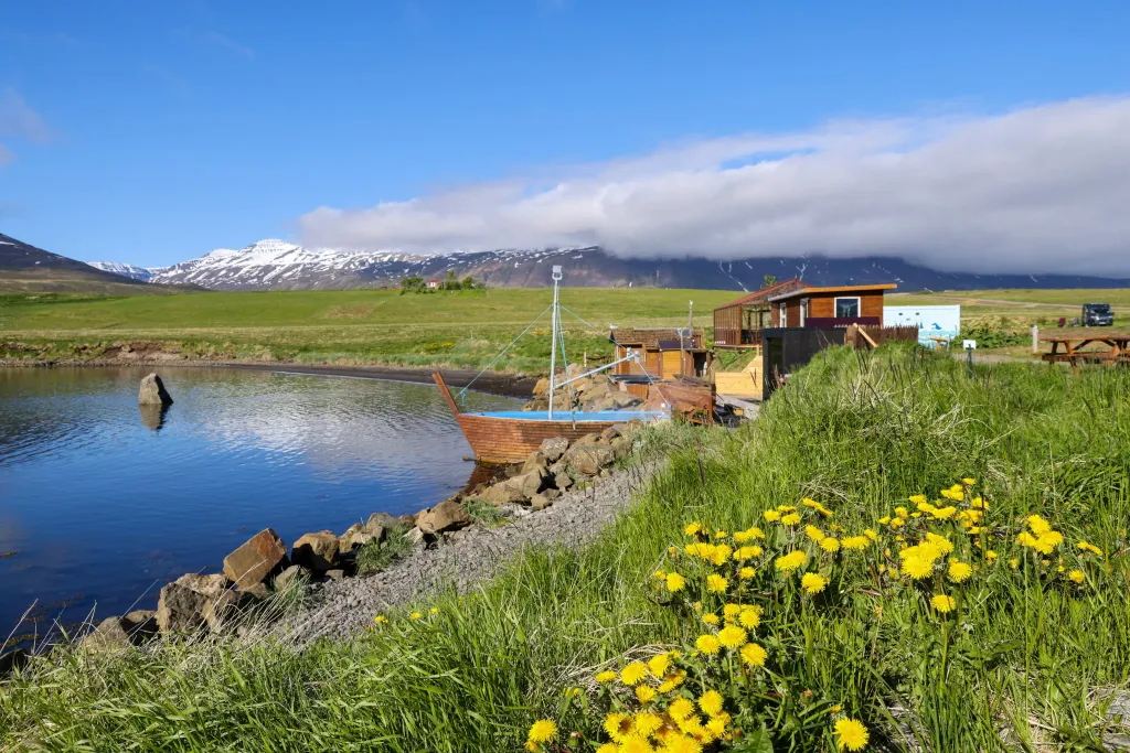 Seaside hot tubs made of stone overlooking the ocean and snowy mountains in Hauganes.