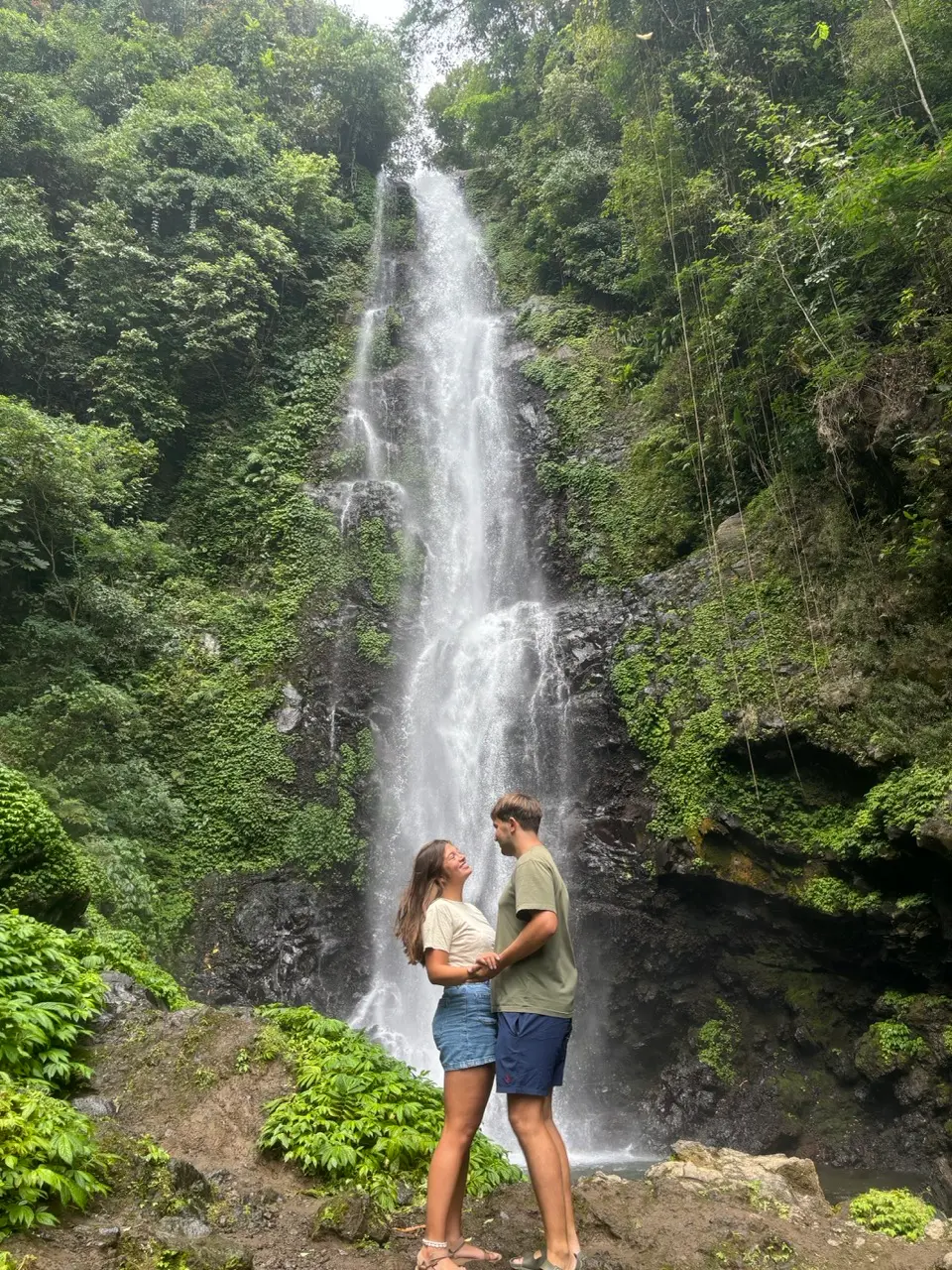 een koppel hand in hand voor een waterval