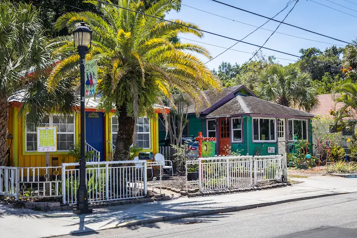 Colorful, charming houses line a sunny street in Bradenton, FL, featuring vibrant exteriors, lush palm trees, and a relaxed atmosphere, captured in September 2026.