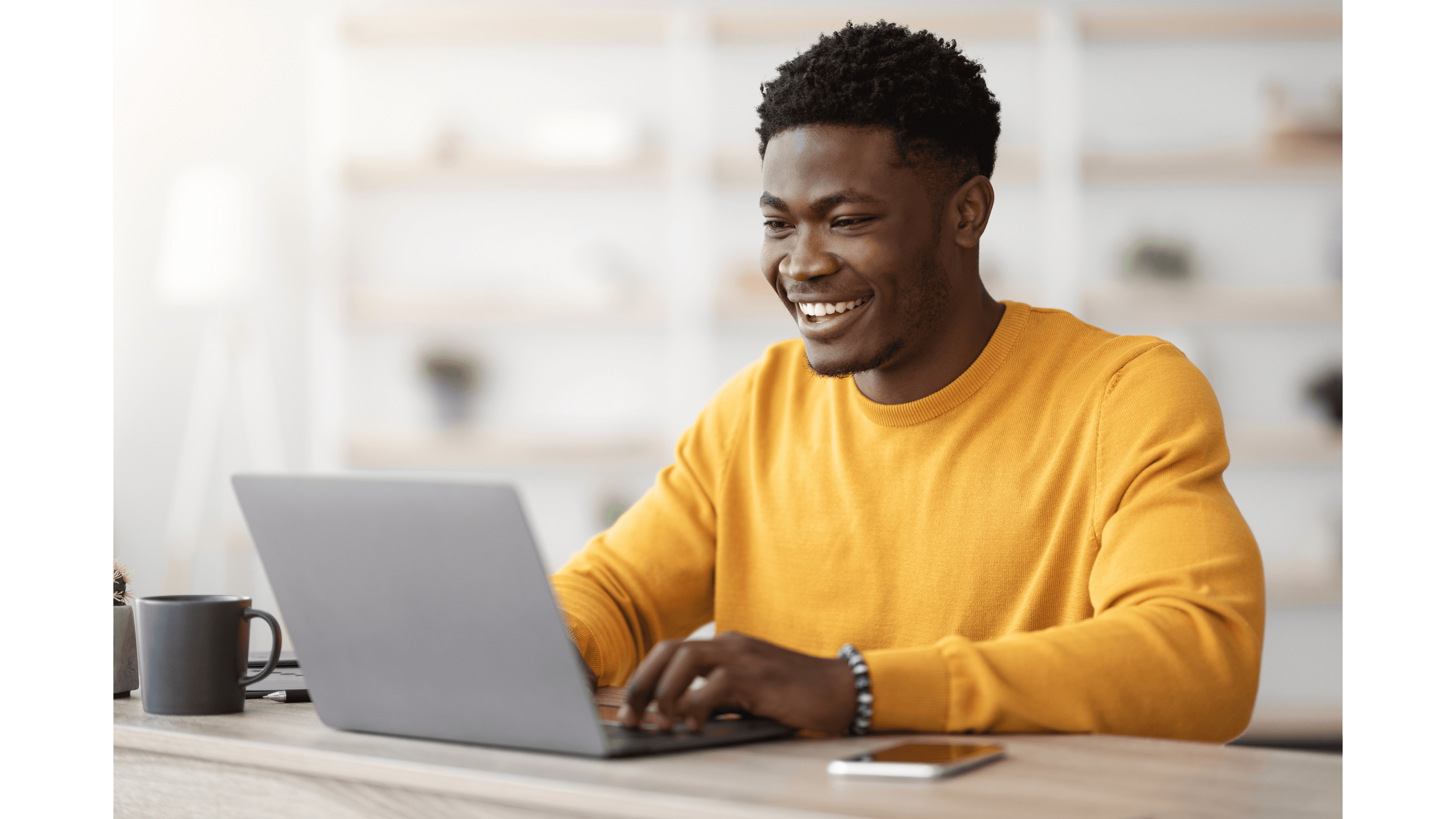 A man smiling in front of his computer