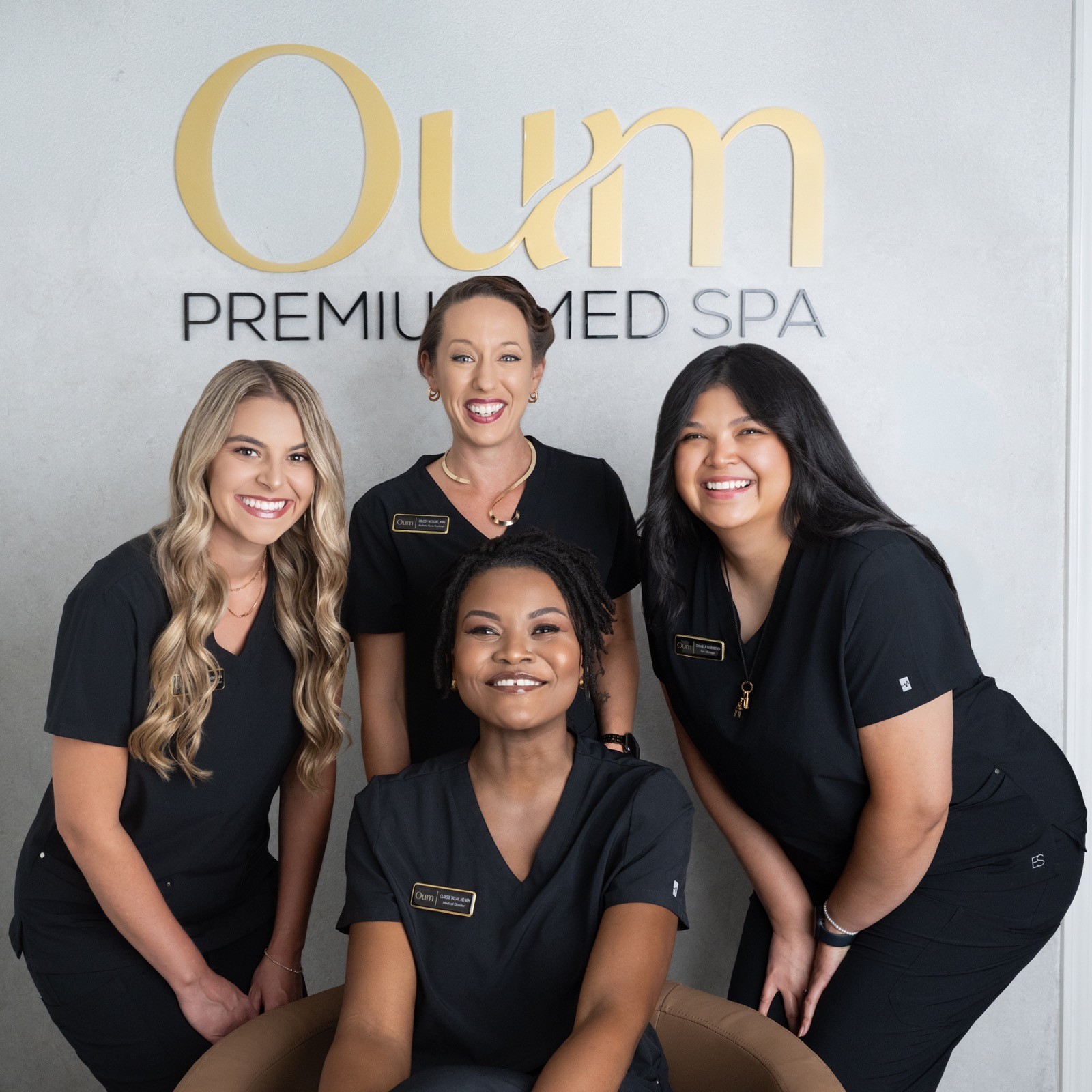 The Oum team together beneath the Oum Premium Med Spa sign