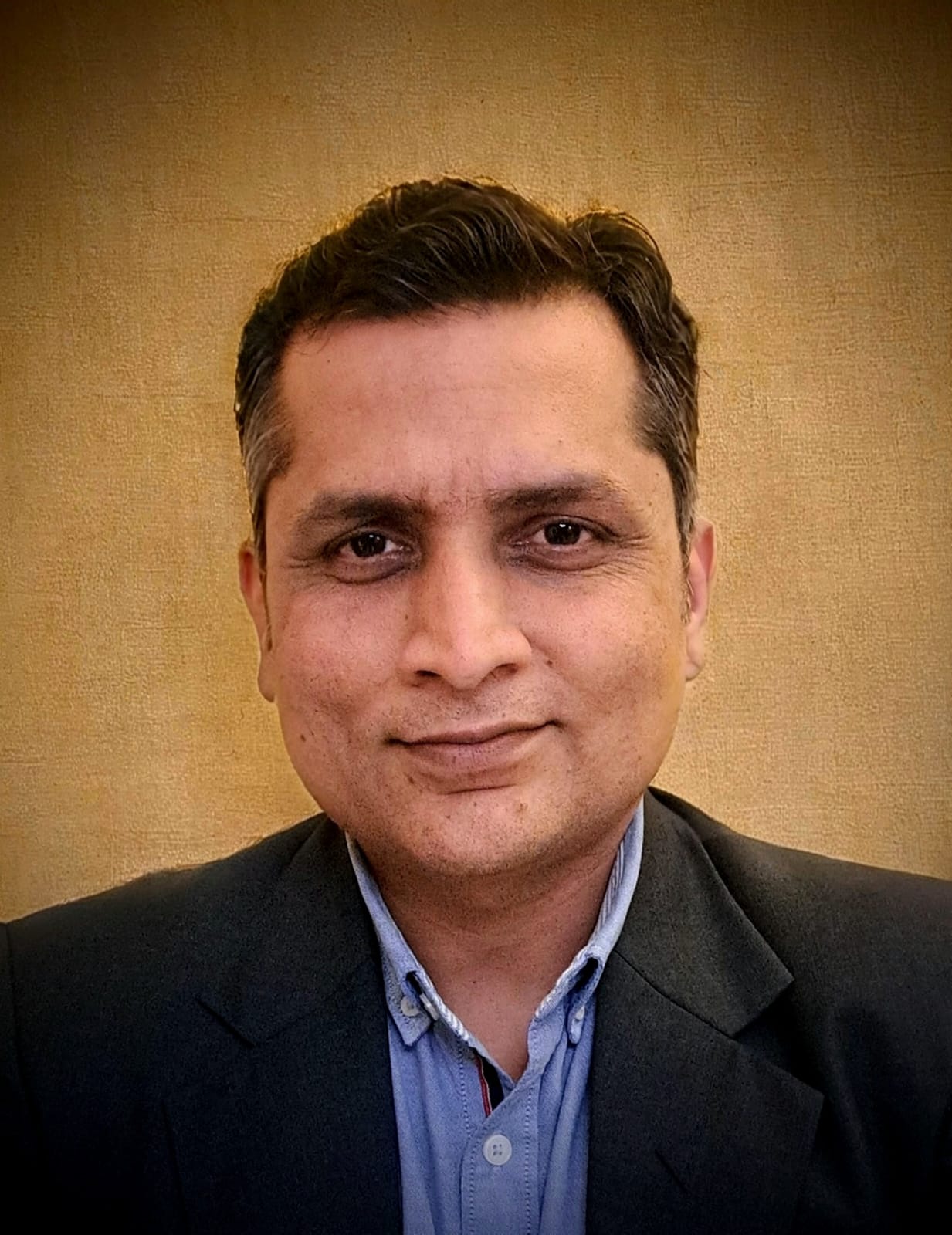 Close-up portrait of a freckled woman with soft pink hair and star earring, natural light, white tank top.