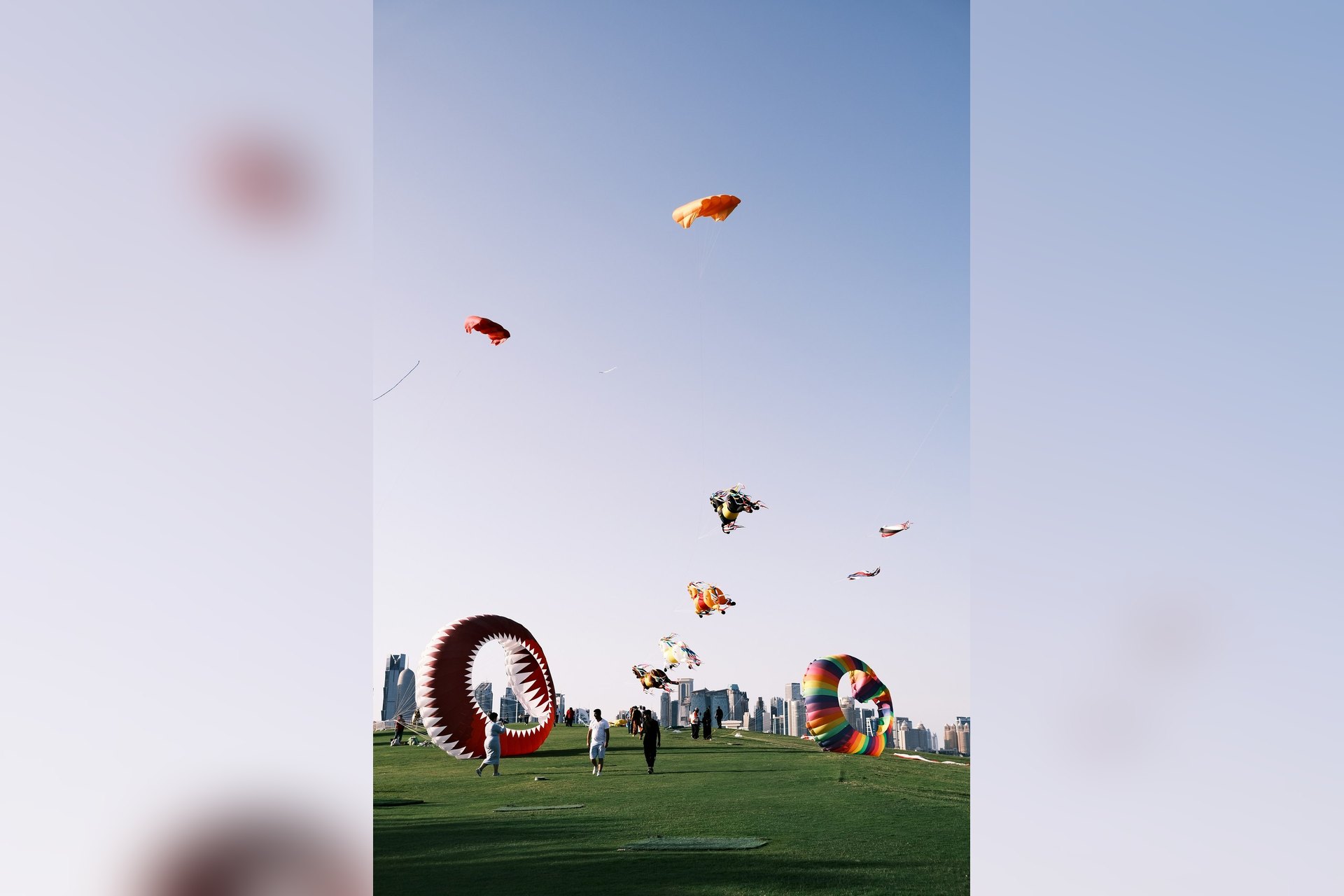 Des enfants et leurs parents font voler des cerfs-volants géants dans le parc du Musée d'art islamique, face aux tours de Doha