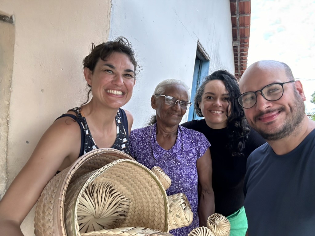 Hóspedes da Casa Ingapura compram cestarias de buriti com Dona Conceição, artesã tradicional do povoado Bar da Hora.
