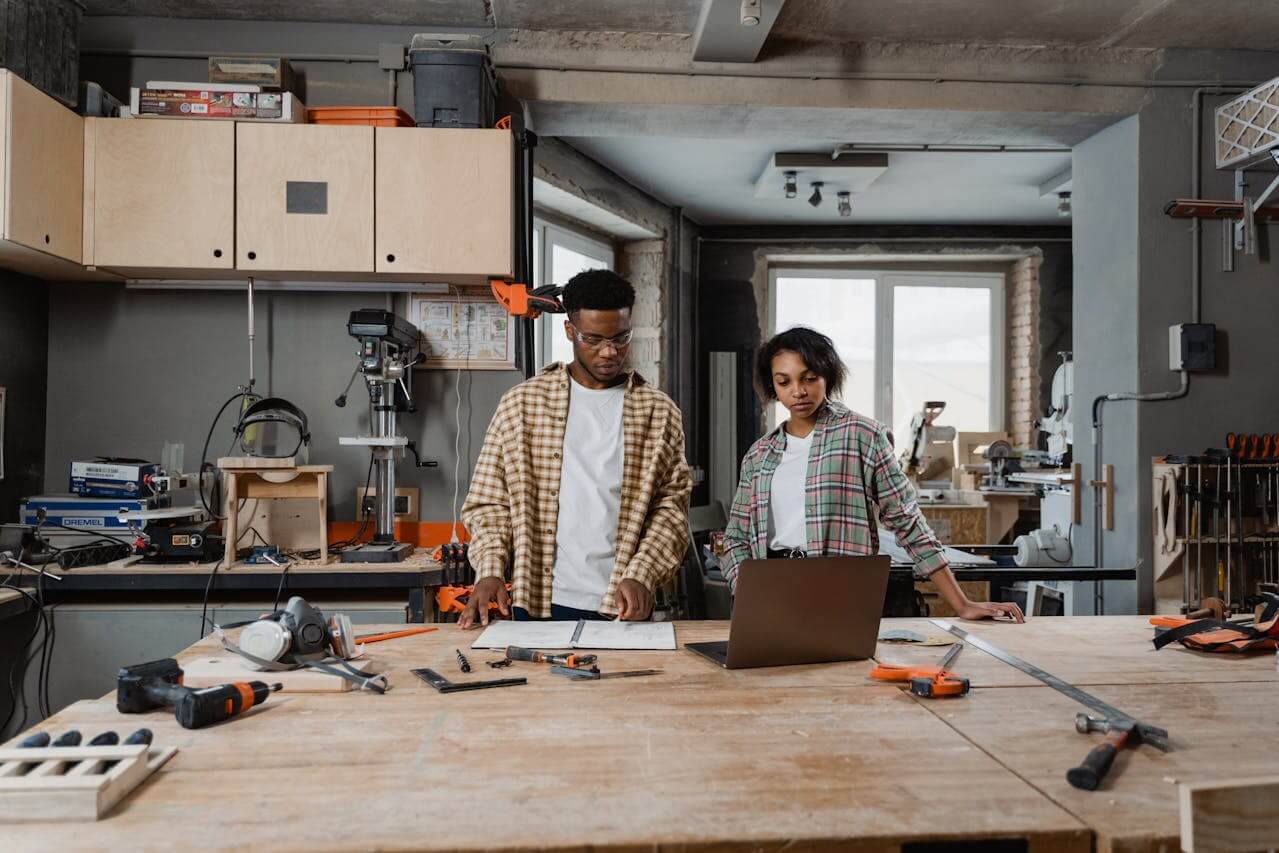 clothes iron, hammer, axe, flashlight and pitcher on brown wooden table