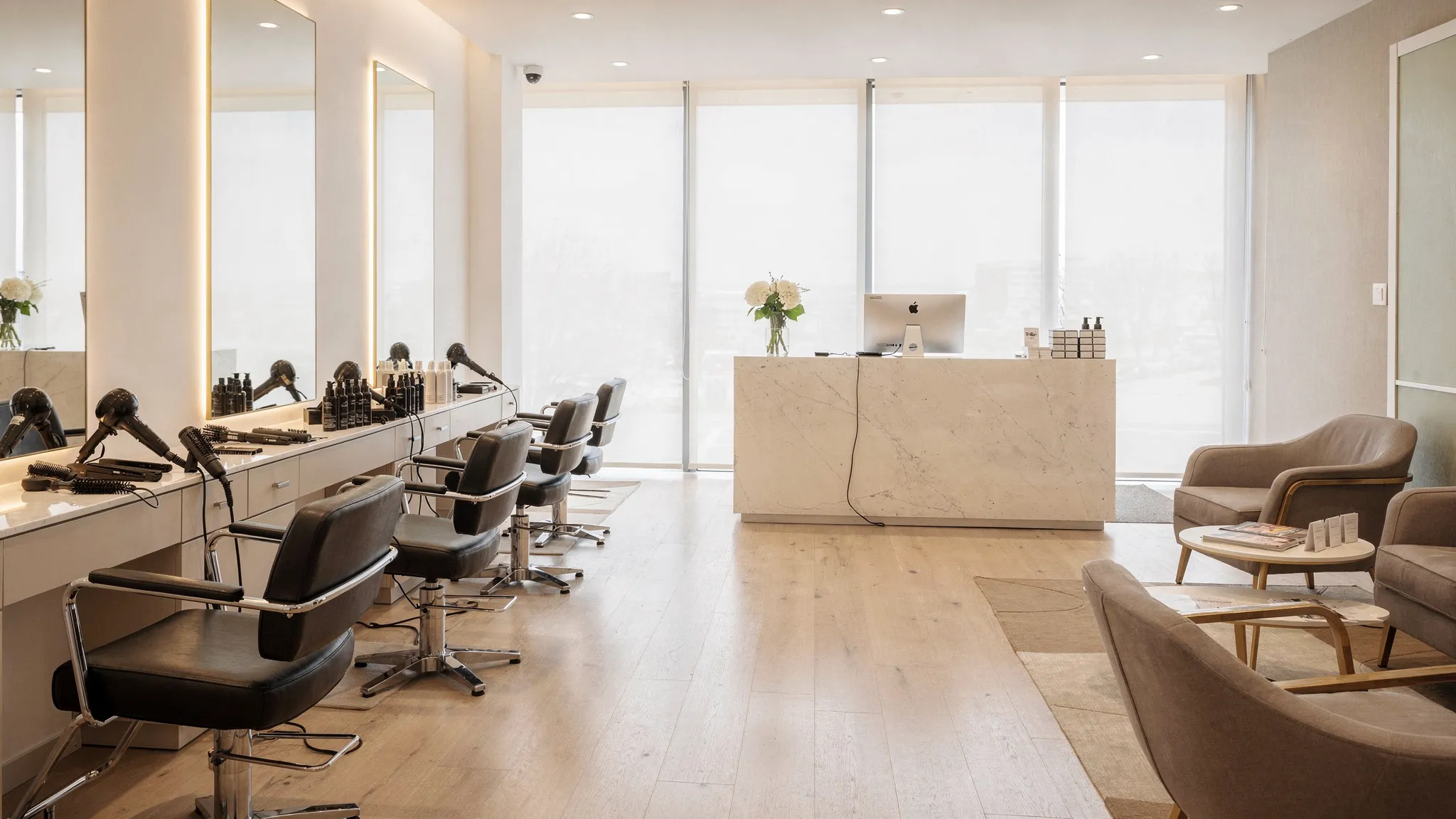 A bright luxury hair salon with styling chairs, mirrors, professional hair tools, and a welcoming reception area prepared for client appointments.