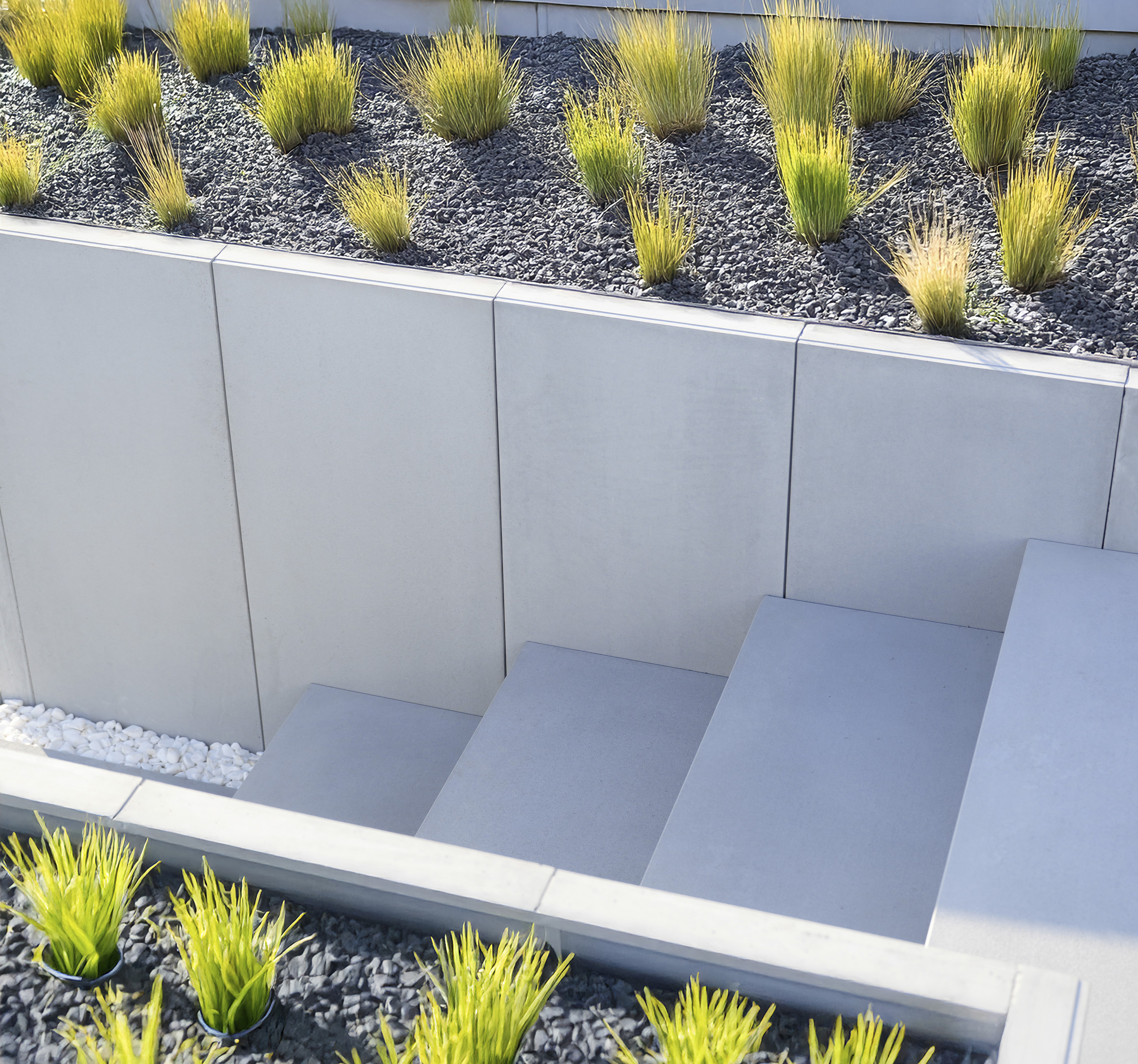 Modern house with large windows, a stone walkway, and landscaped grass, framed by trees under clear blue skies.