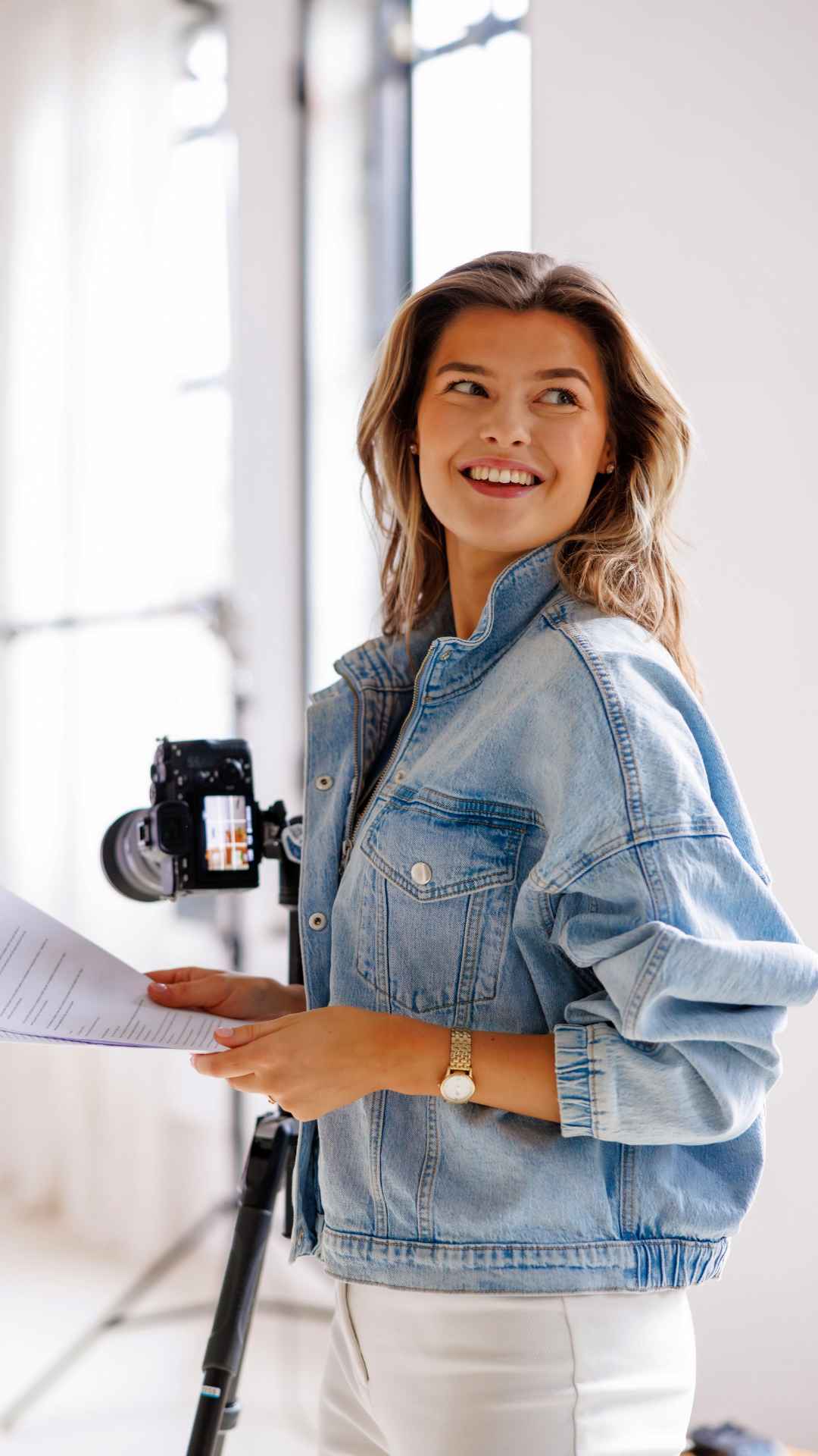 Dried herbs hang near a window with a quote.